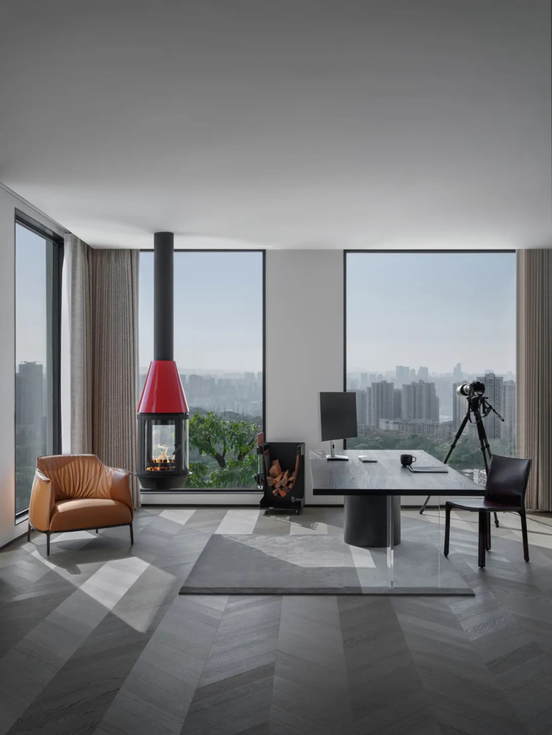 Modern office space featuring a sleek black desk, wooden floor, and large windows overlooking a cityscape.