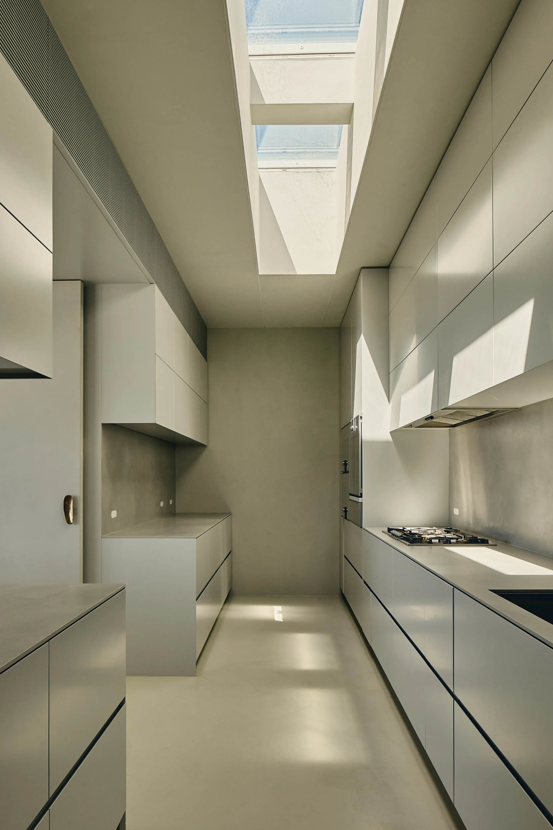 Modern white kitchen with concrete countertops and minimalist design.
