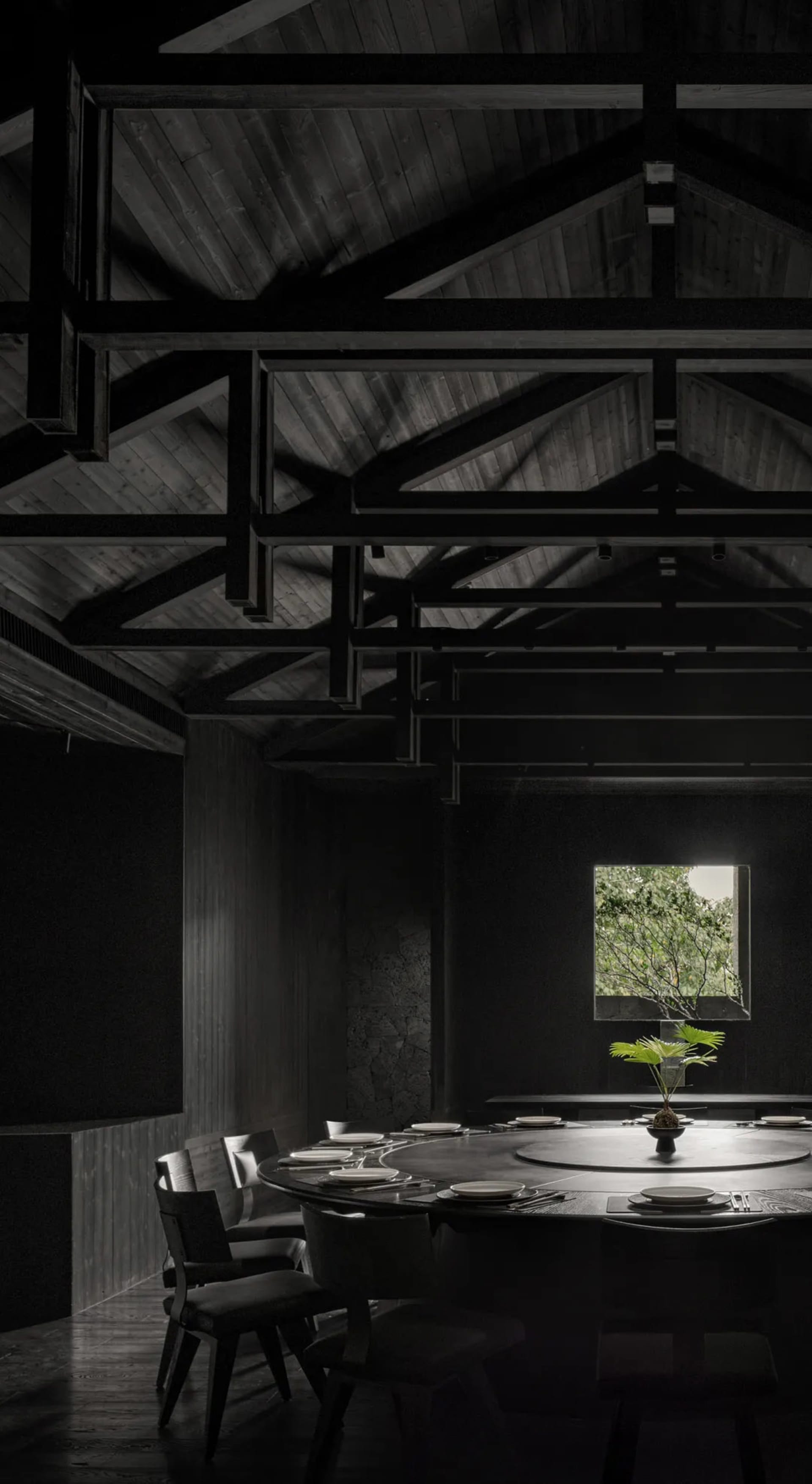 A modern minimalist restaurant interior with dark tones and wooden materials.