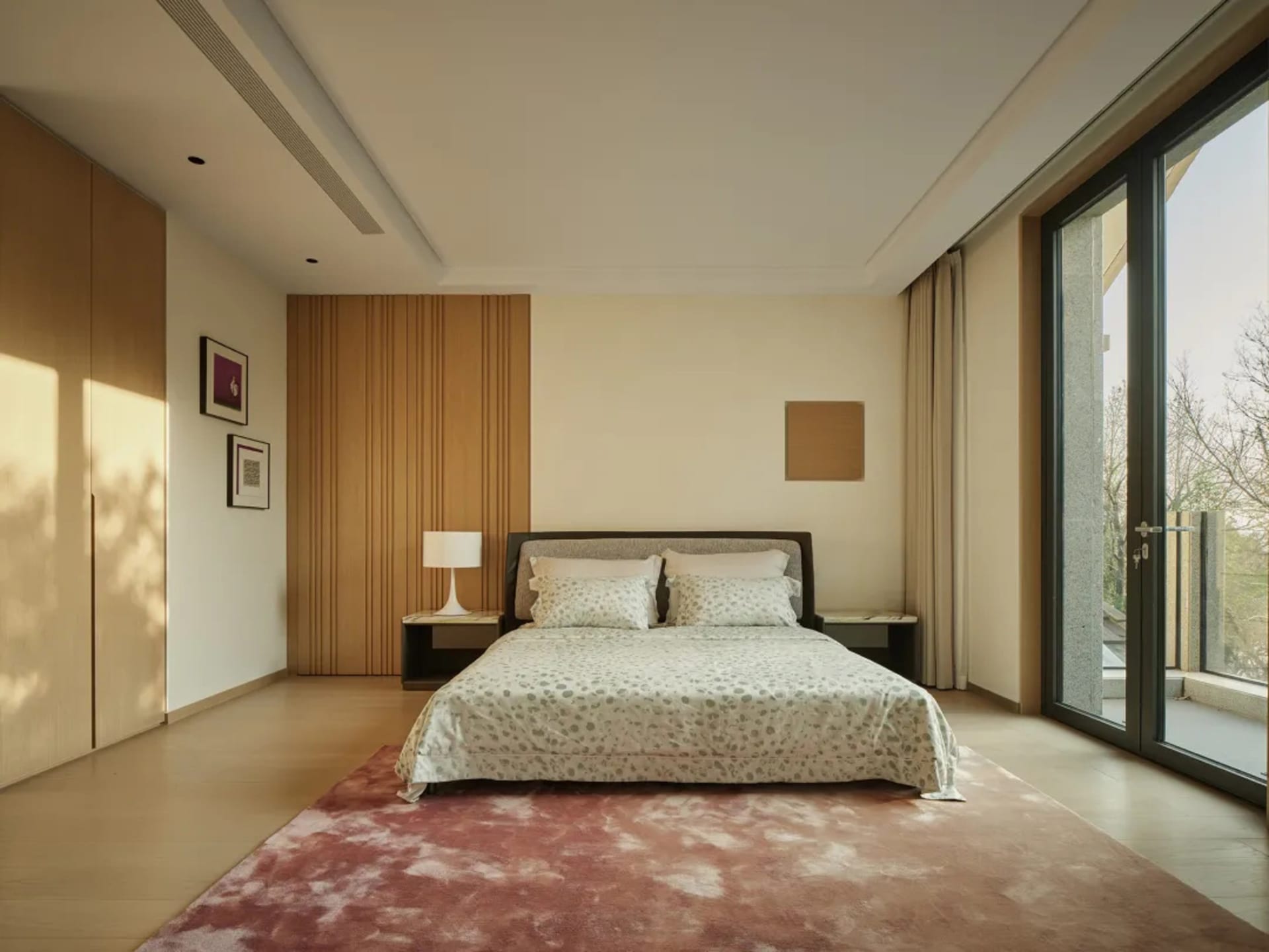 A modern bedroom featuring a carpeted floor, wooden headboard, and glass sliding doors.