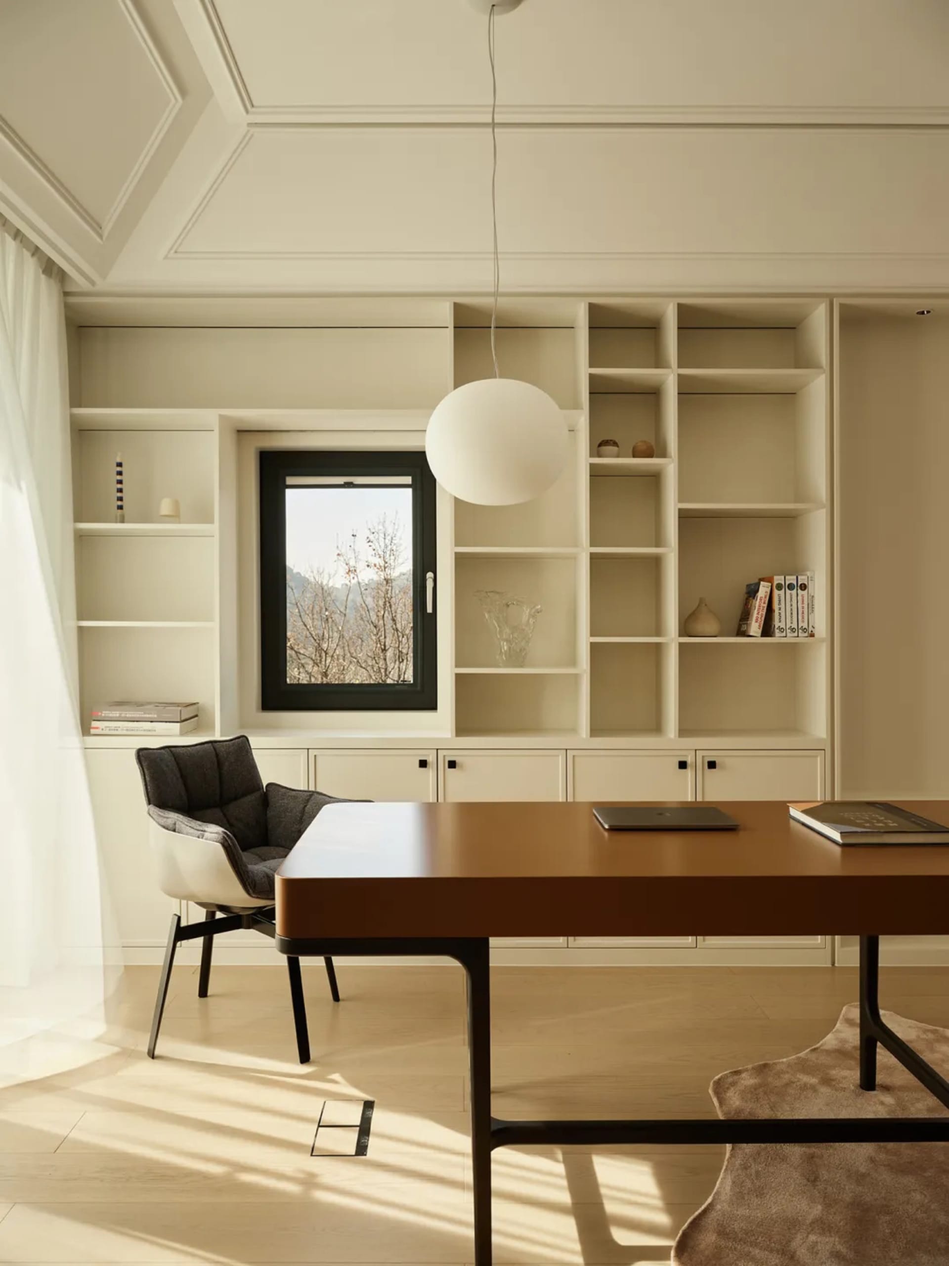 A modern home office featuring a wooden desk, bookshelf, and comfortable chair.