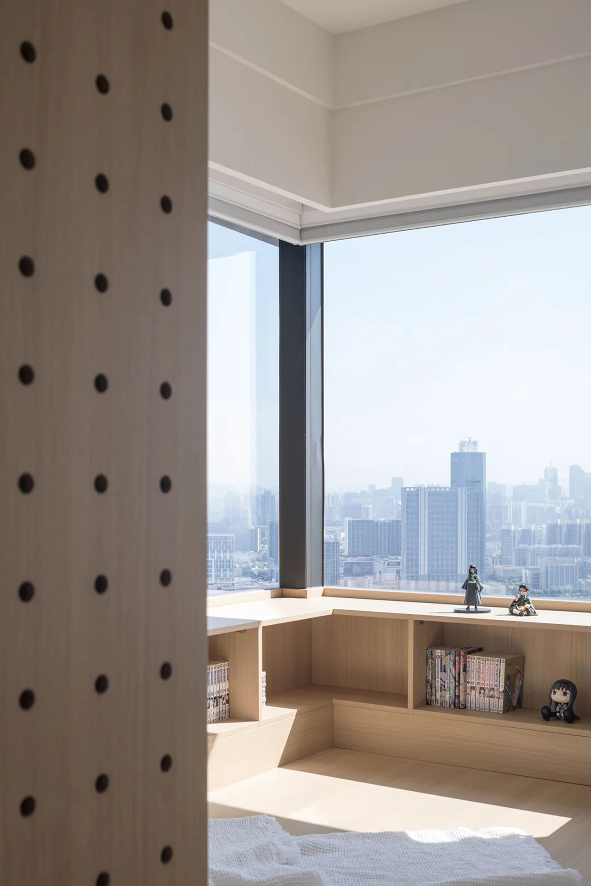 Modern room featuring wood shelves and a city view.