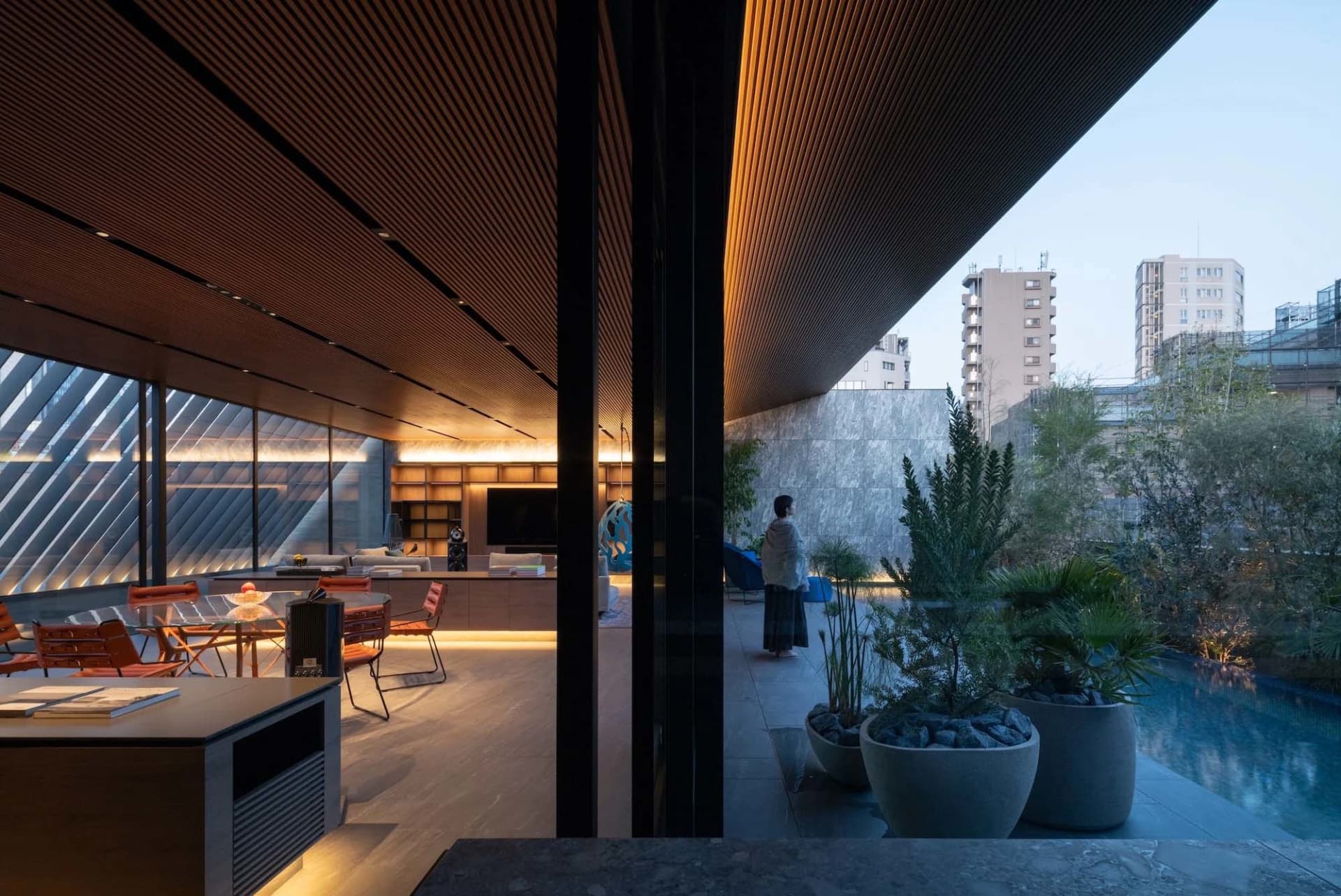 A modern residential pool deck featuring wood and concrete elements.