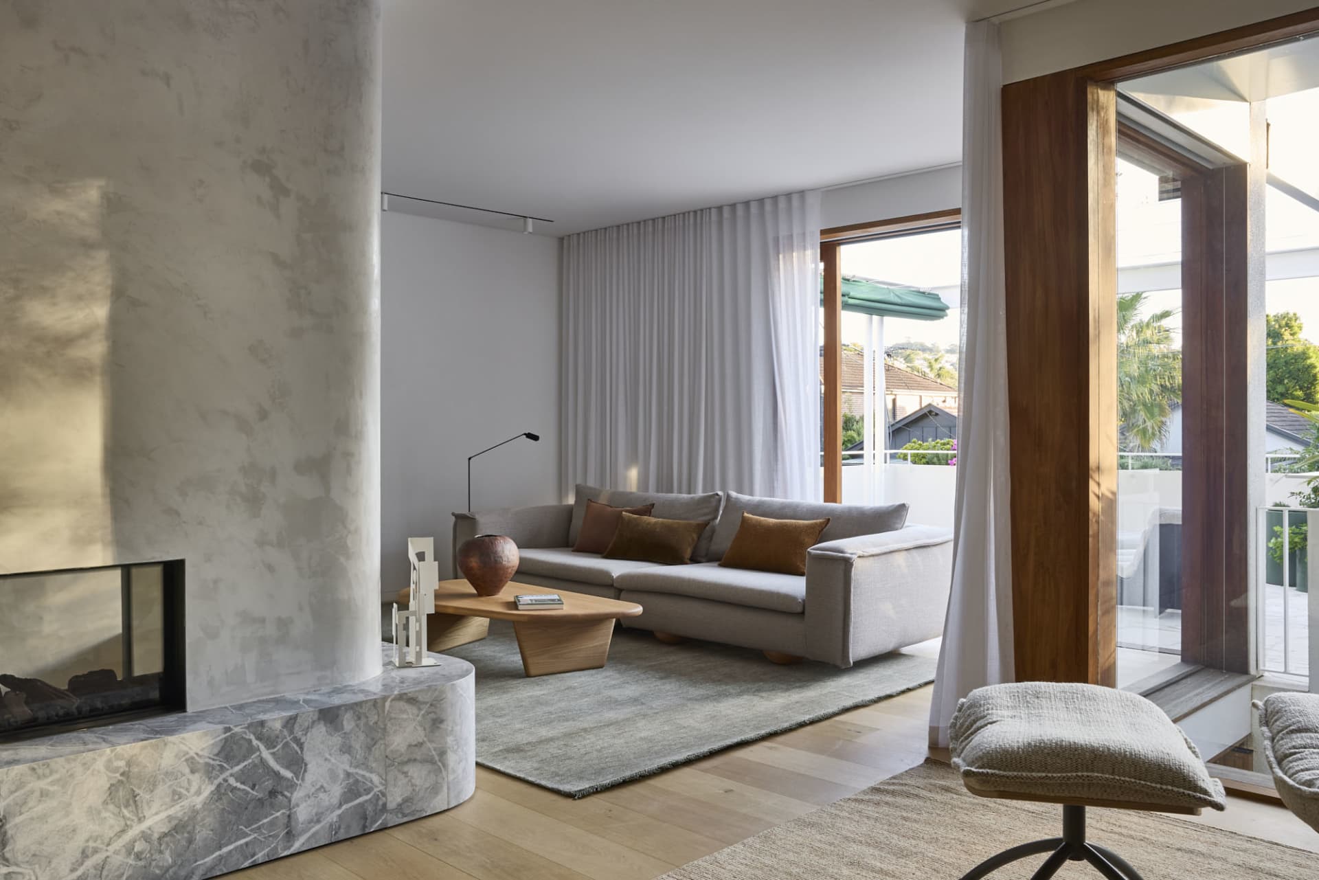 Modern living room with a marble fireplace and concrete walls
