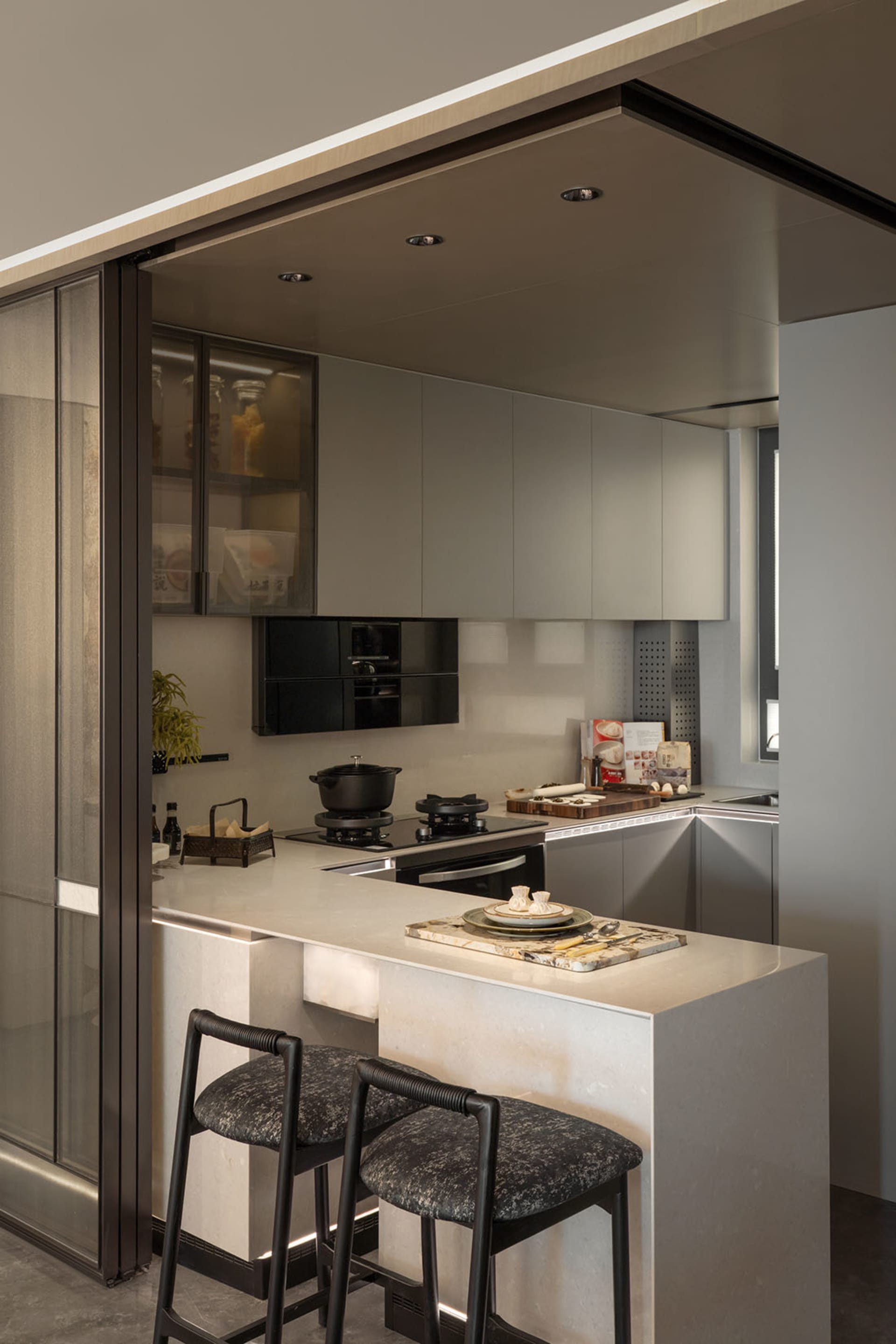 A modern, minimalist kitchen featuring marble countertops and sleek, contemporary cabinetry.