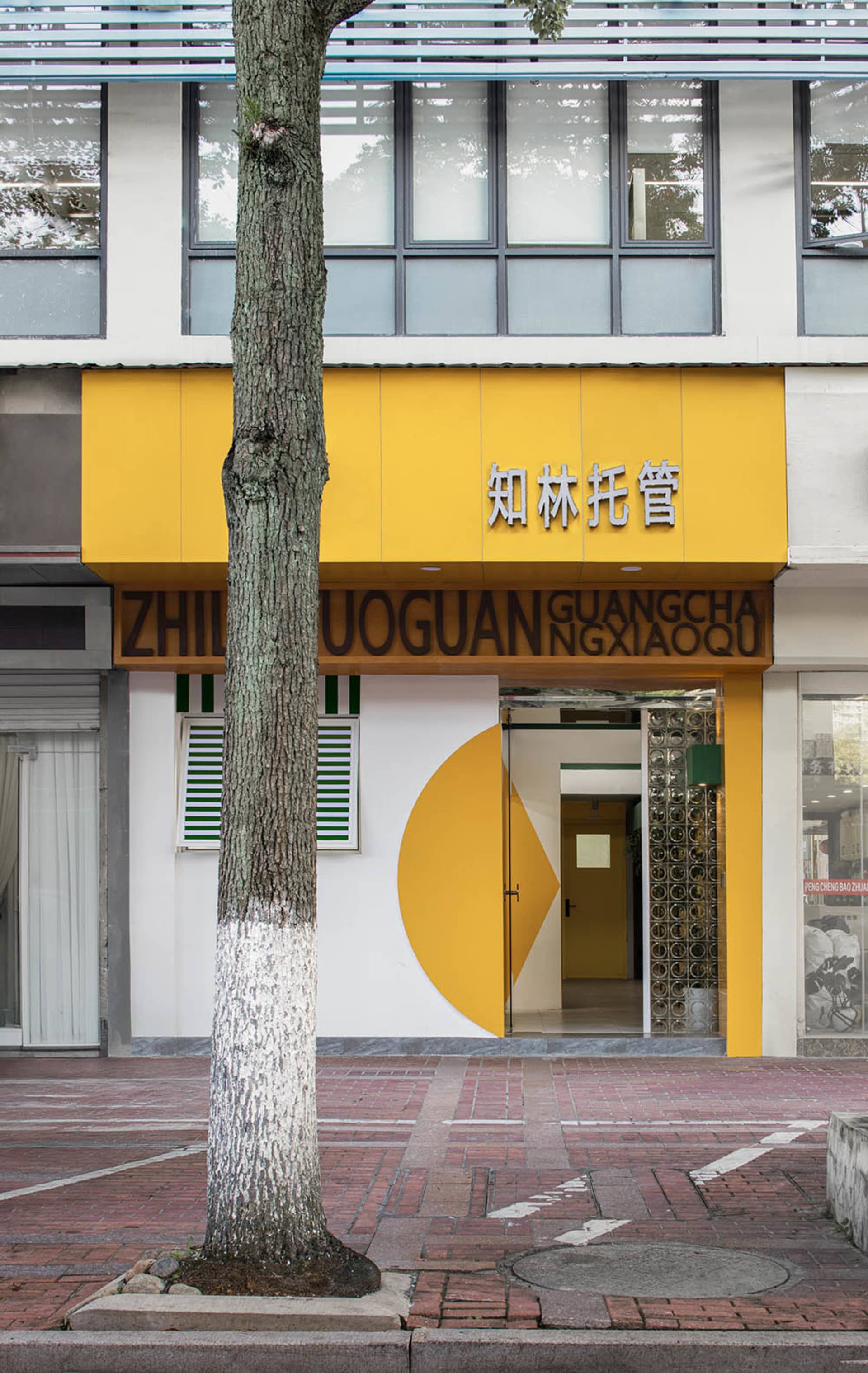 一棟黃色外牆的現代建築,上面有黑色中文字符。