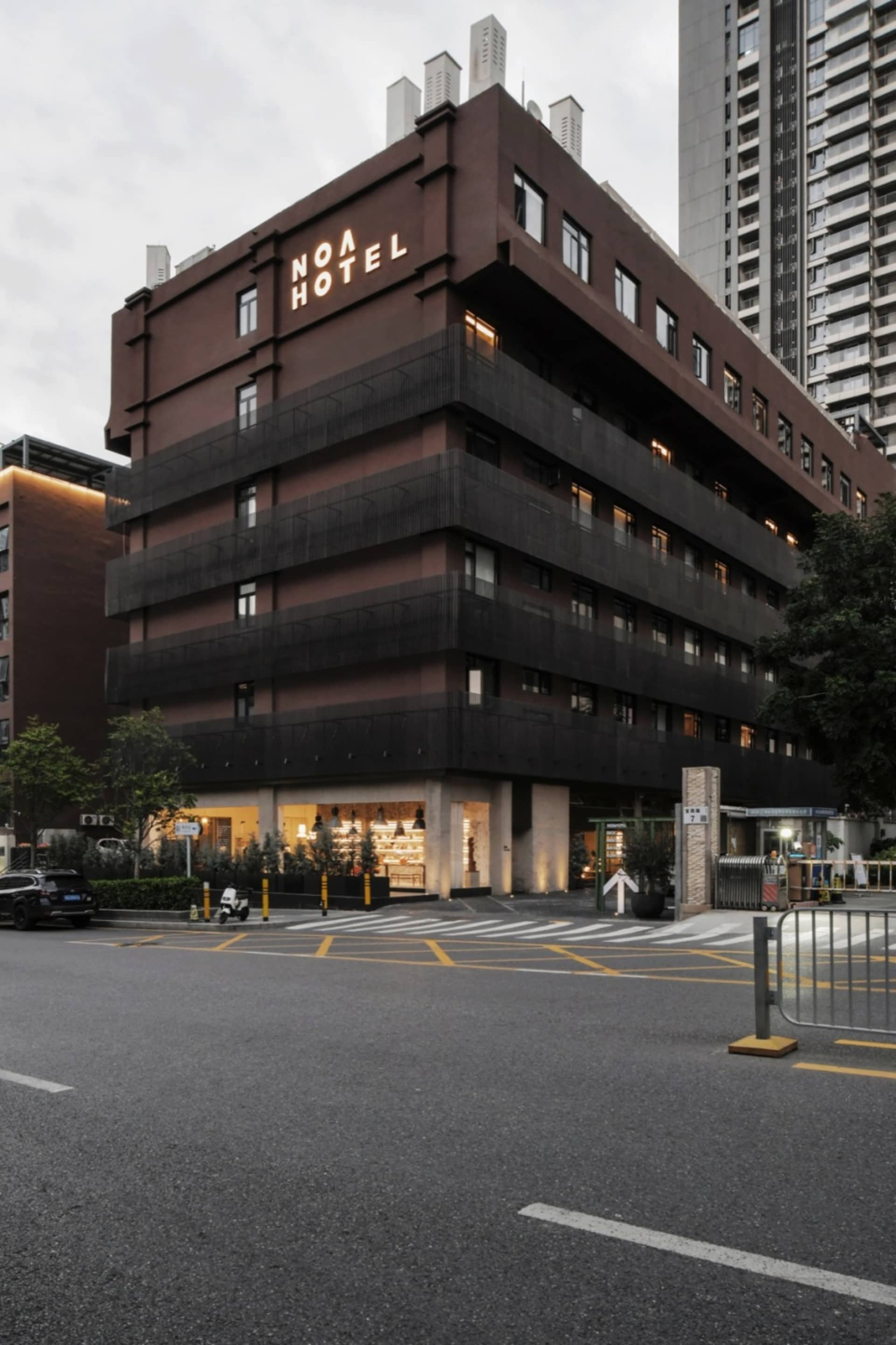 A modern hotel building with a black concrete exterior.