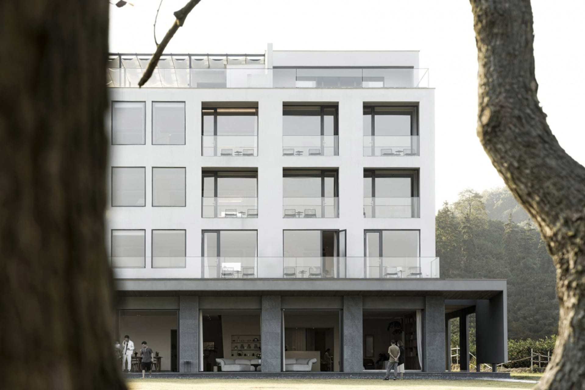 Modern apartment building with a concrete exterior and large glass windows.