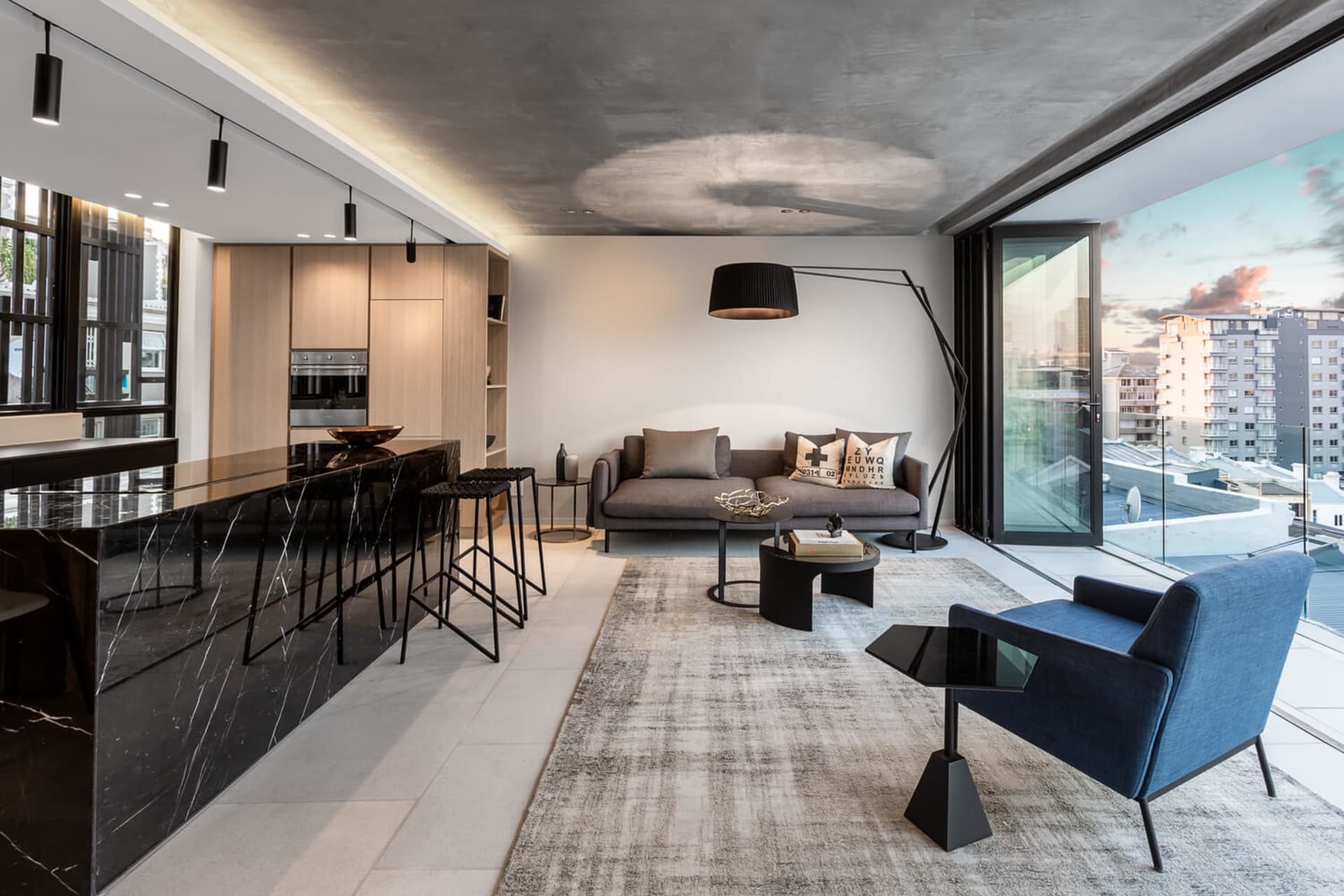 A modern residential living room featuring a concrete floor and marble accents.