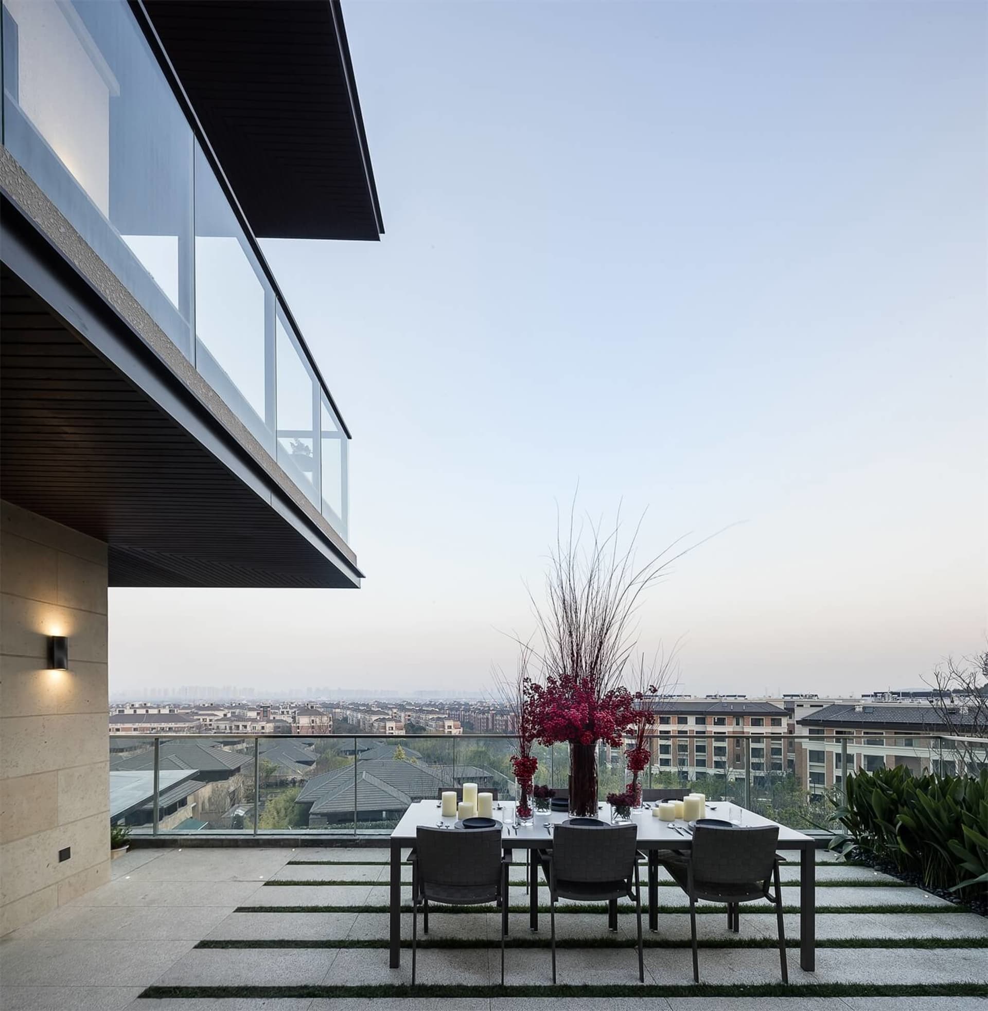 A modern dining room with transparent glass panels and a view of the cityscape.