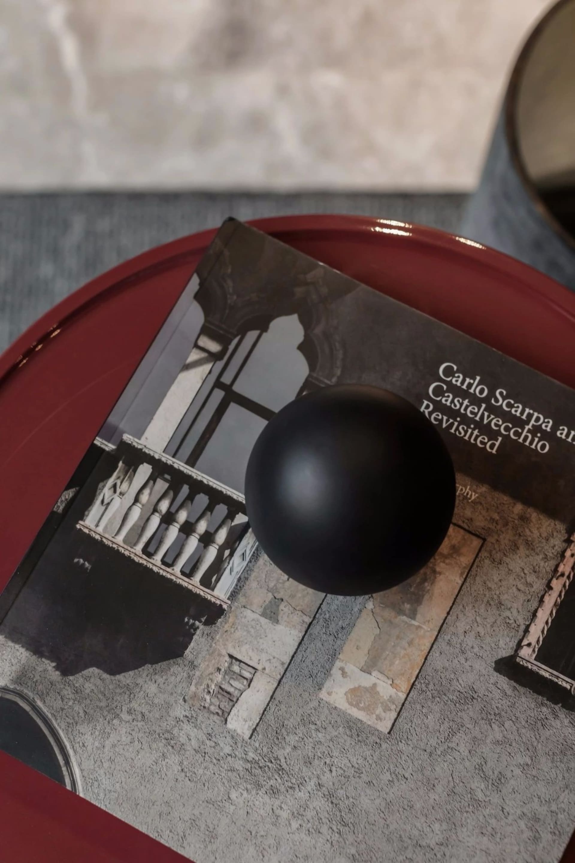 A photorealistic depiction of an interior design featuring a black sphere and a book with architectural imagery.