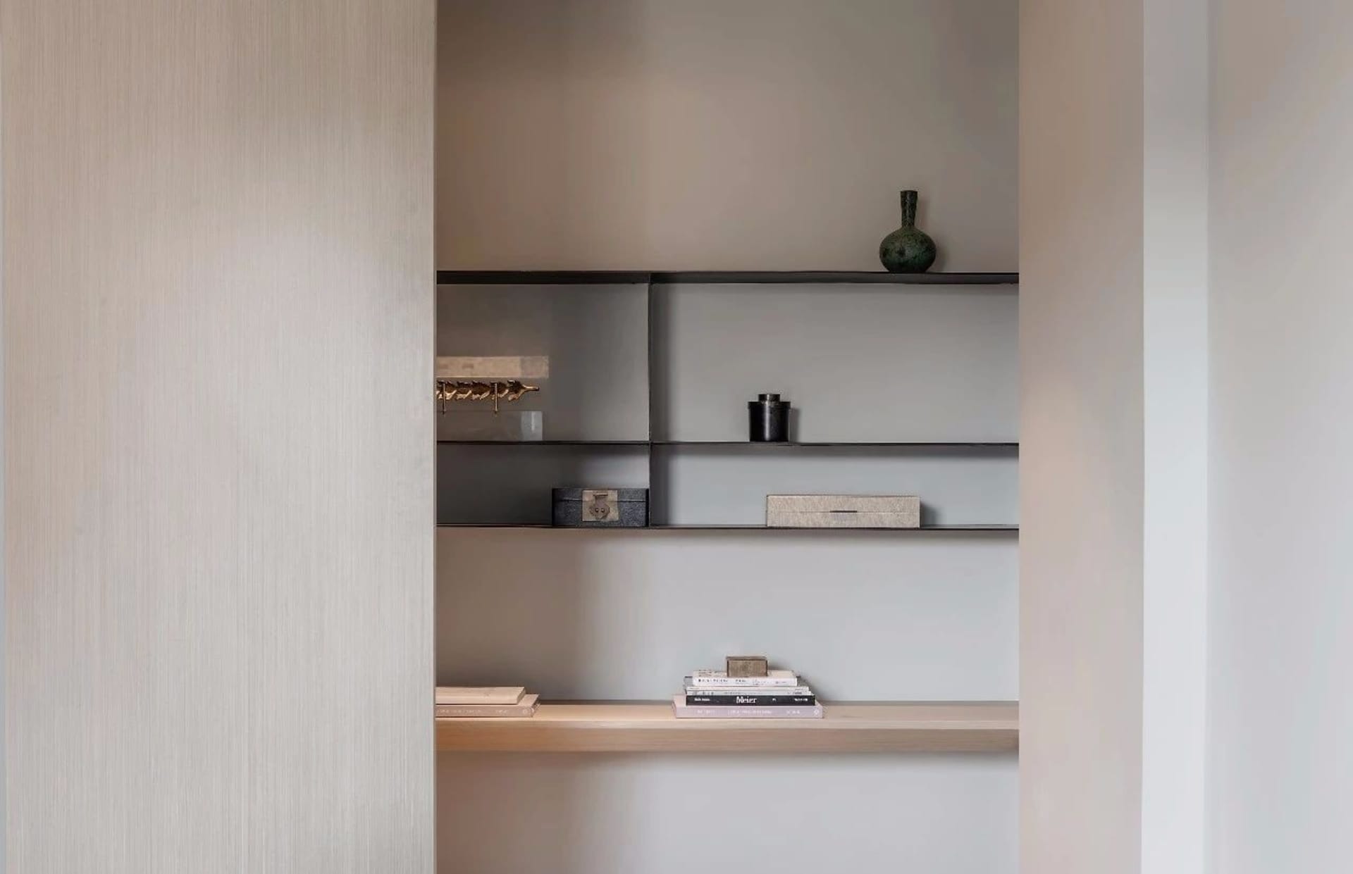 Minimalist modern interior closet with metal shelves and black accents.