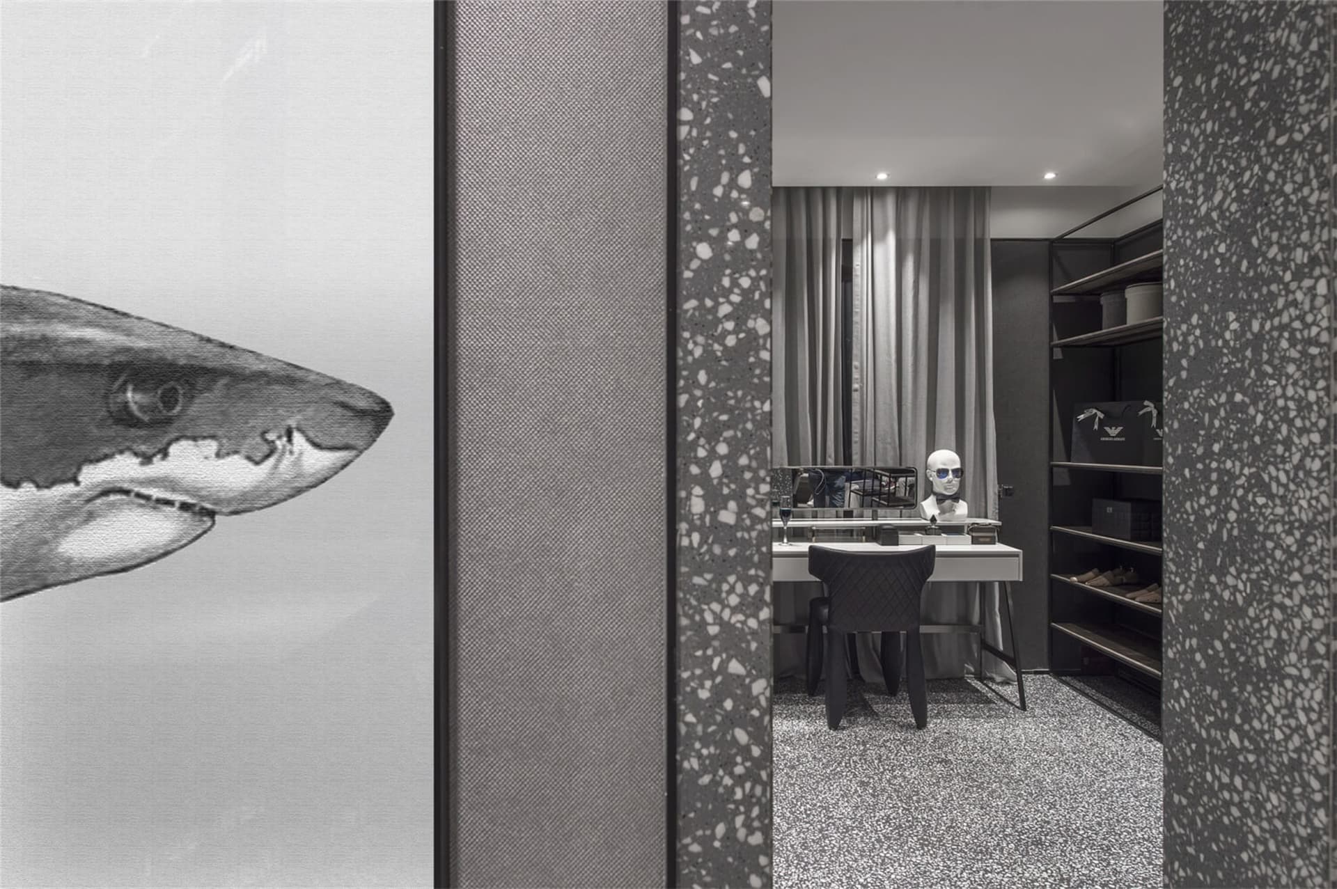Modern black and white clothing retail store featuring a minimalist interior with a terrazzo floor and minimalist decor.