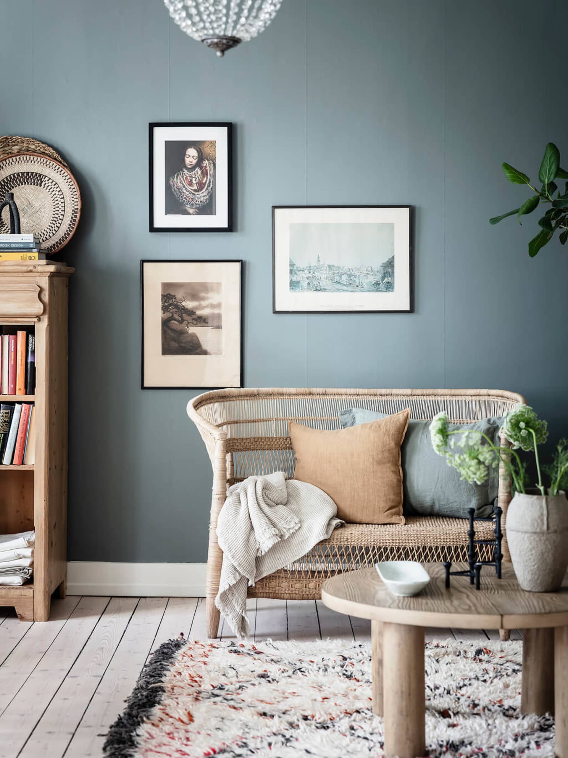A cozy industrial-style living room featuring a rattan sofa and wooden furniture.