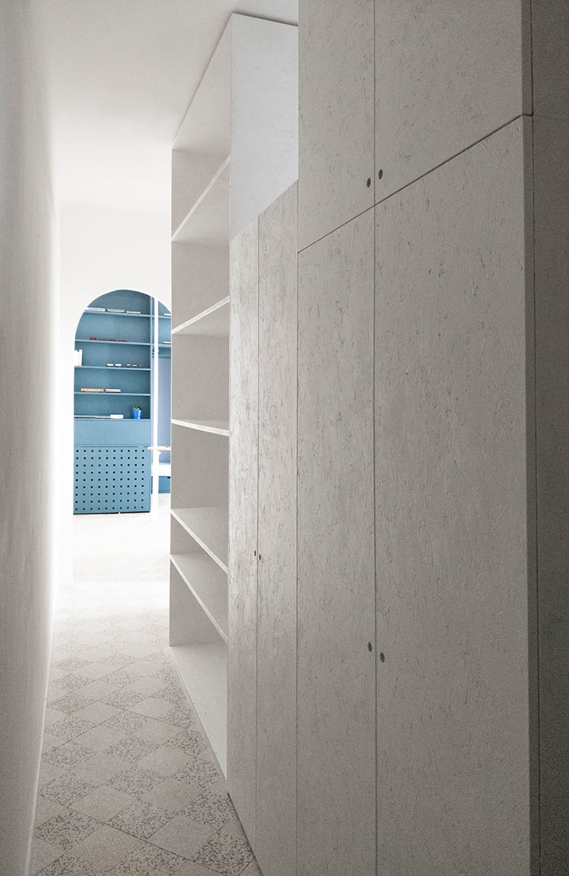 Modern minimalist wardrobe interior with concrete cabinets and shelves.