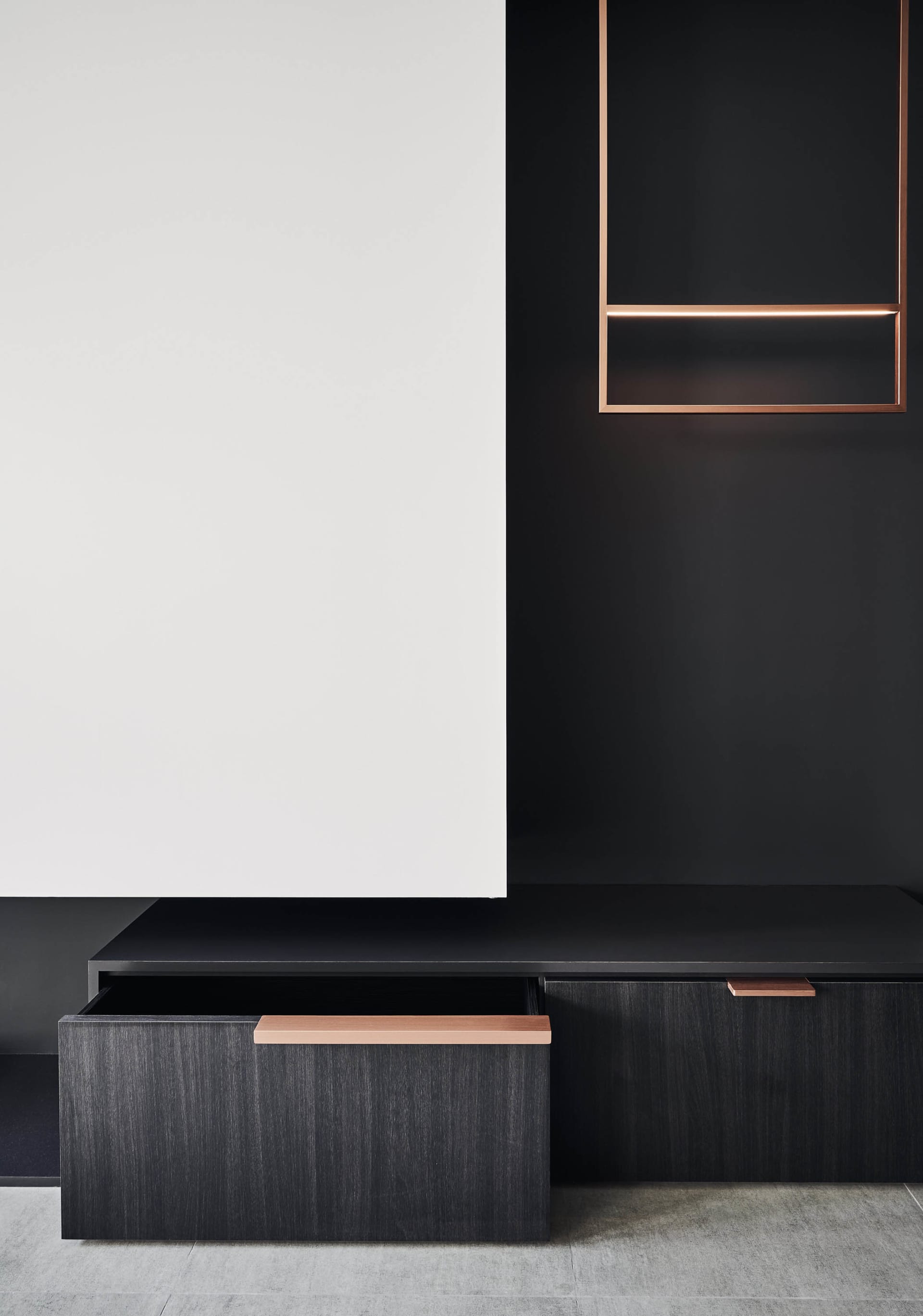 Modern black and white wooden cabinets with open drawers in a minimalist design setting.