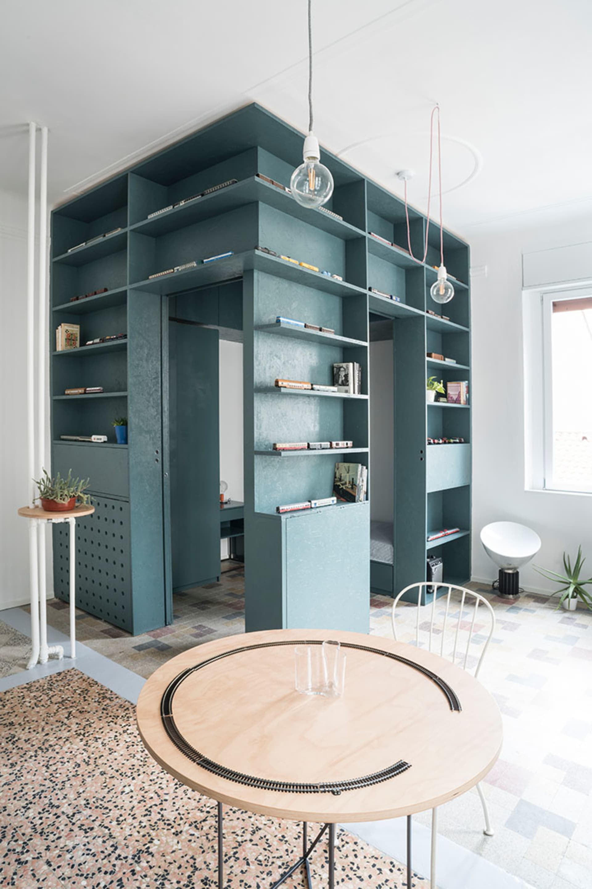 Modern living room with built-in shelving and terrazzo flooring.