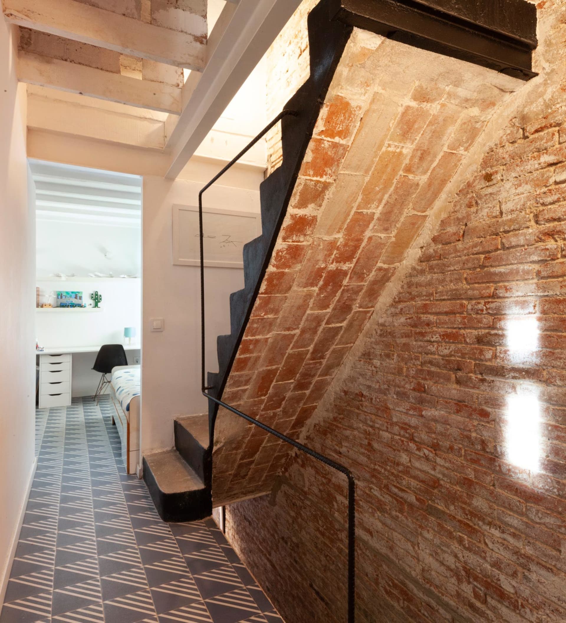 Indoor staircase with brick walls and metal railings in a loft apartment