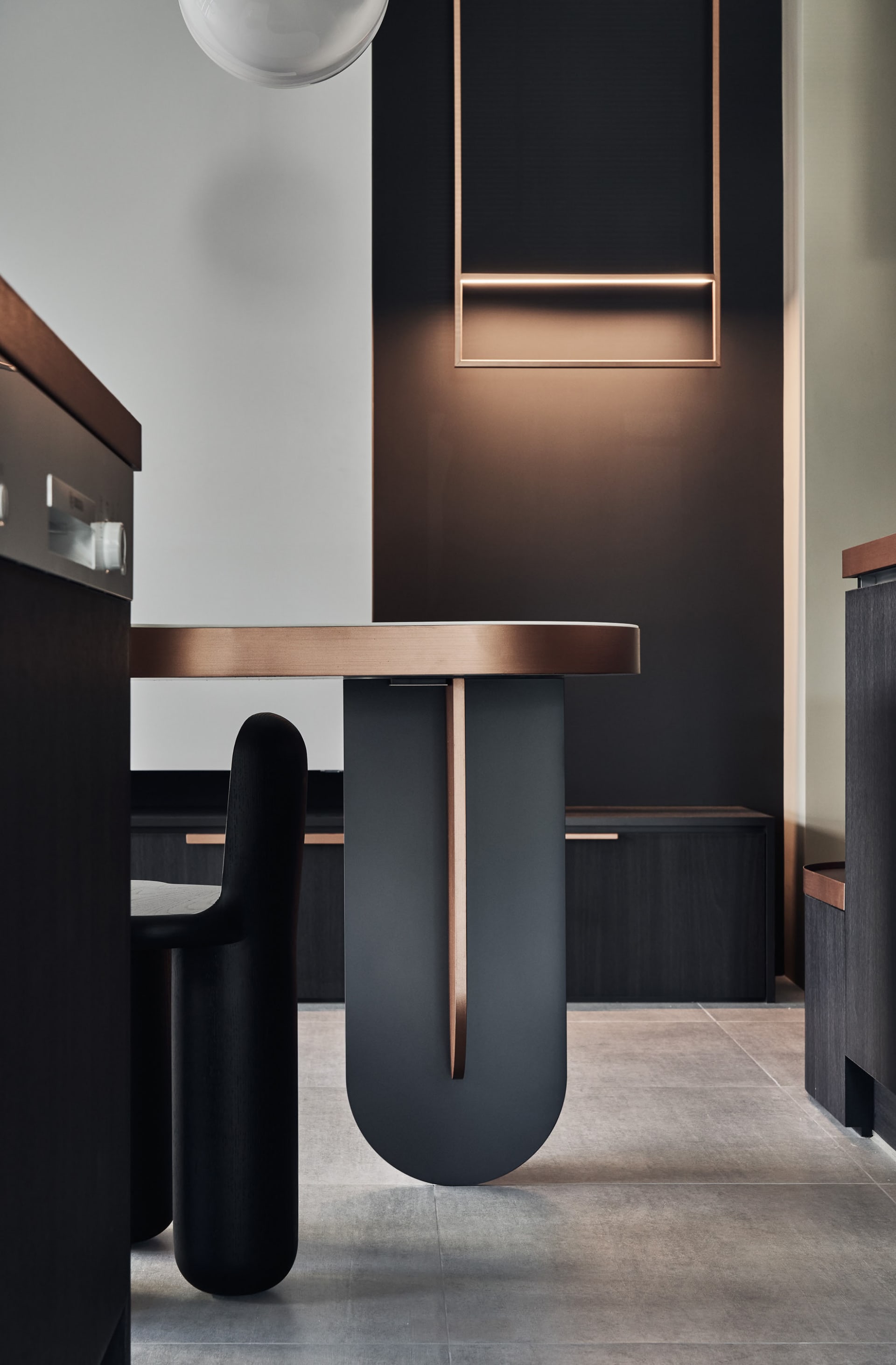 Modern minimalist dining room with a metal table and black chairs.