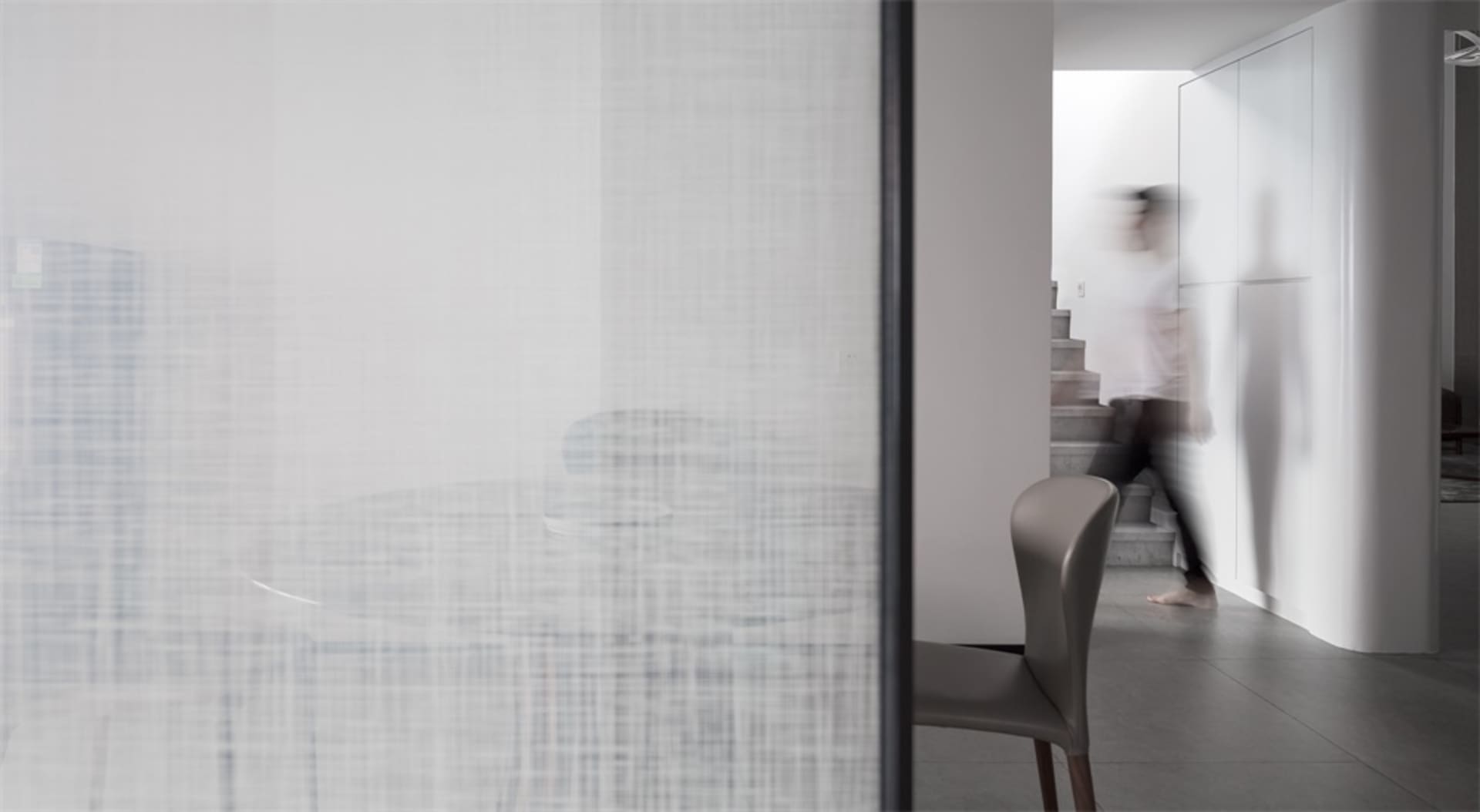 A modern minimalist interior space with concrete features and furniture.