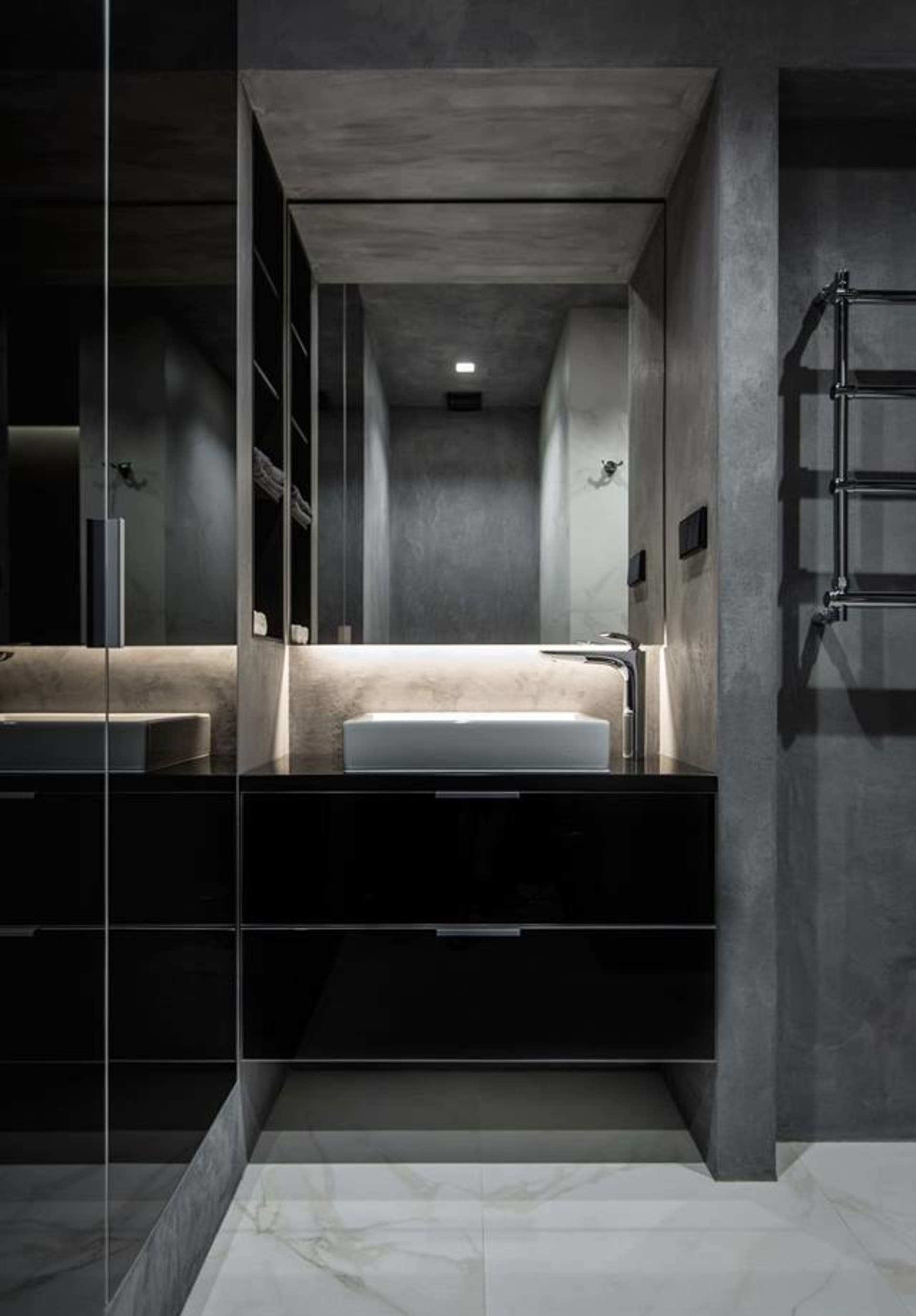 Modern bathroom featuring a sleek, black vanity with a white square sink, illuminated from behind, and a concrete wall with a