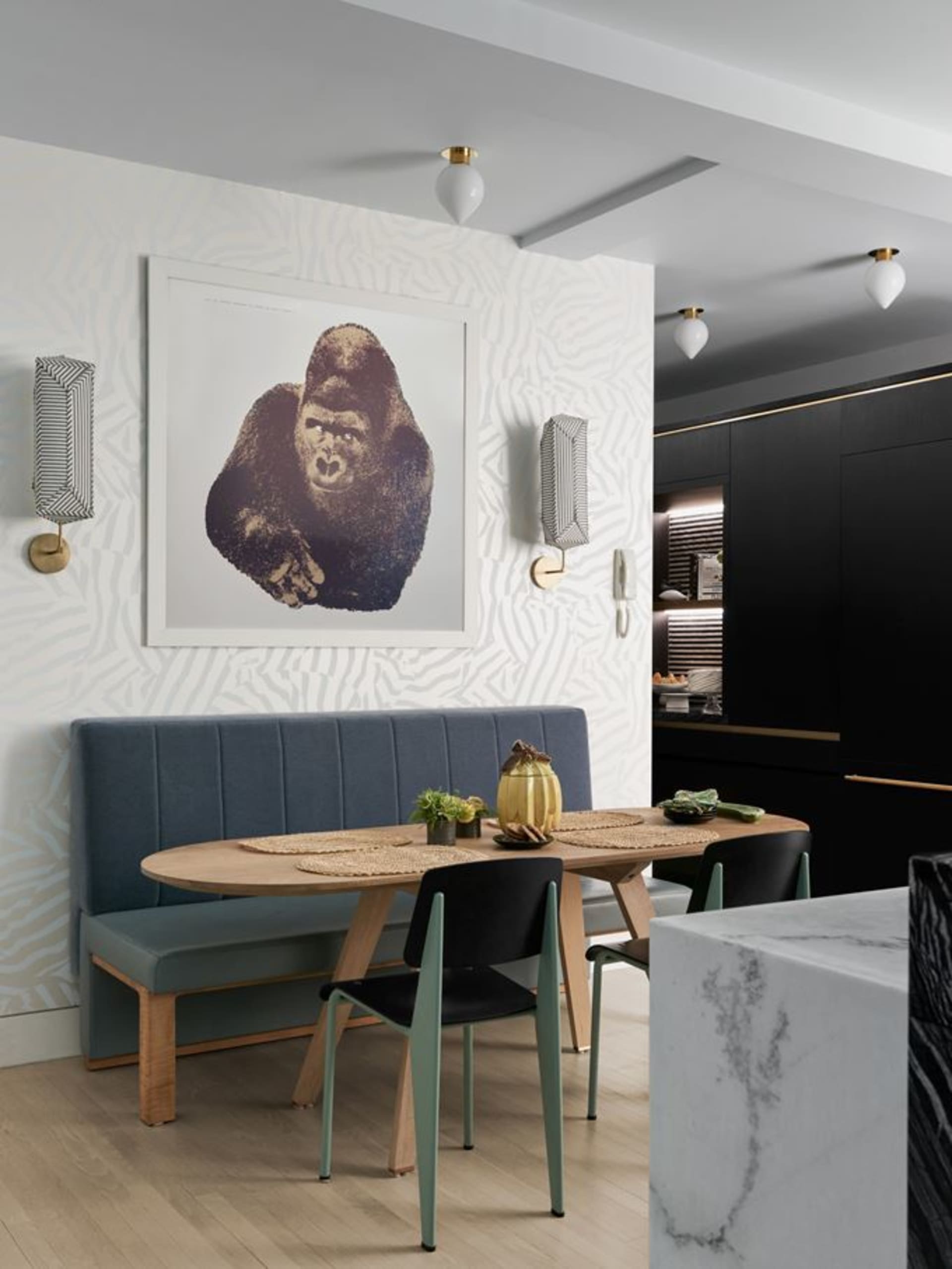 Modern kitchen and dining space featuring textured wood, patterned walls, marble accents, and white elements.