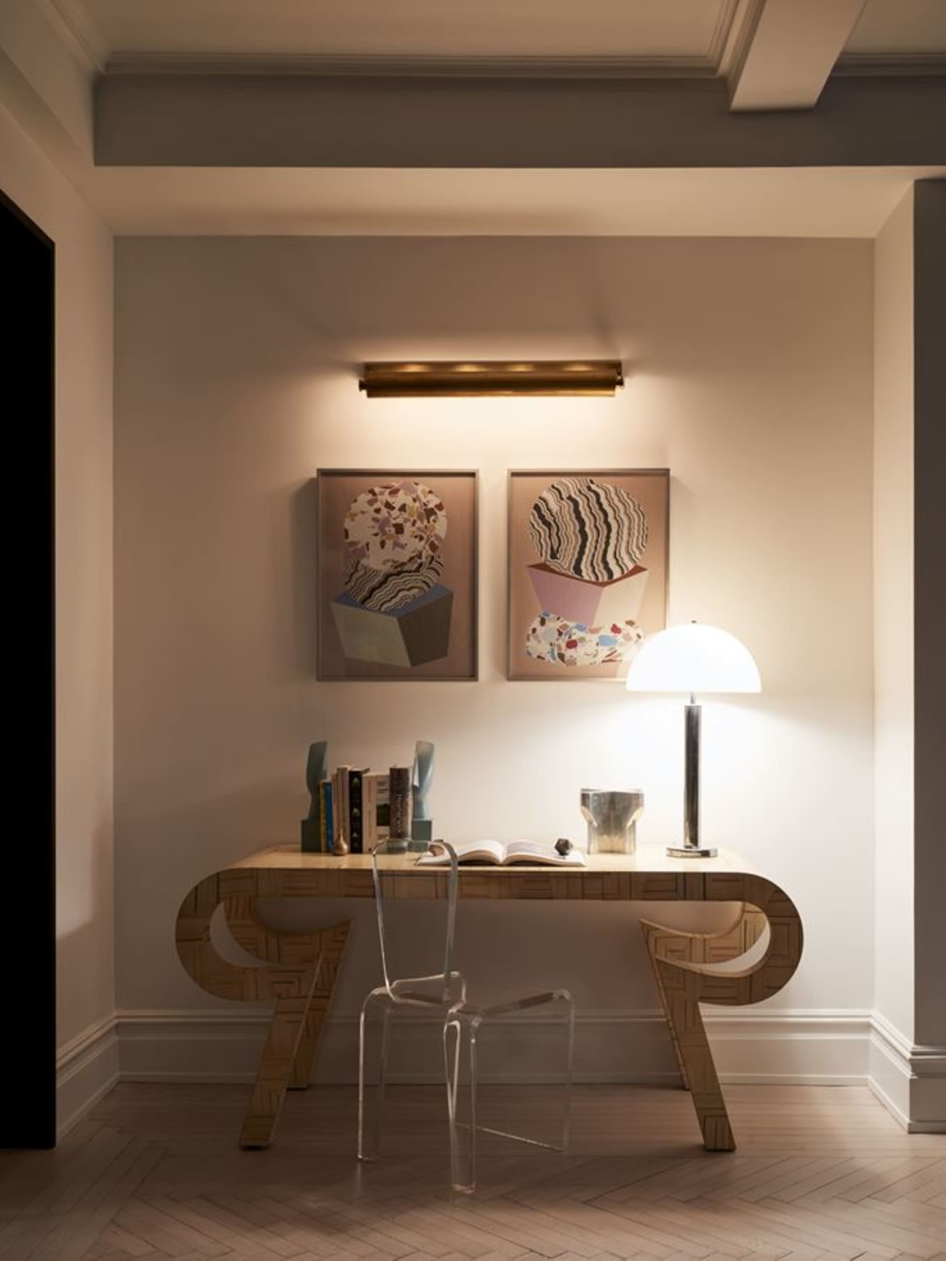 A modern work space featuring a transparent chair and wooden desk.