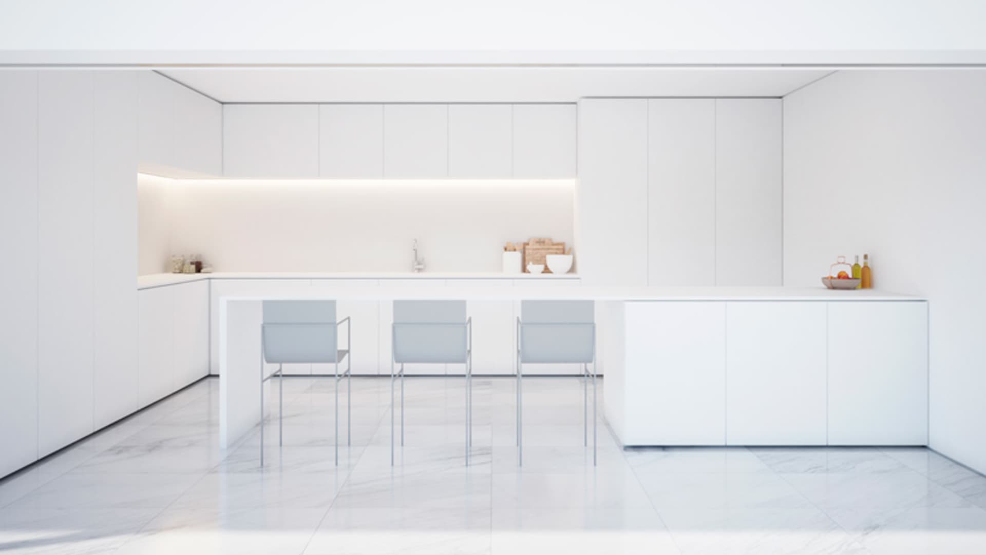 A minimalist white marble kitchen interior with sleek, modern cabinets and a long island.