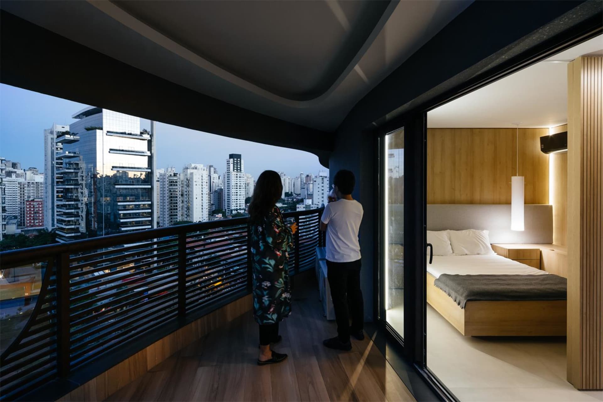 Modern bedroom featuring natural light from a large window overlooking the cityscape.