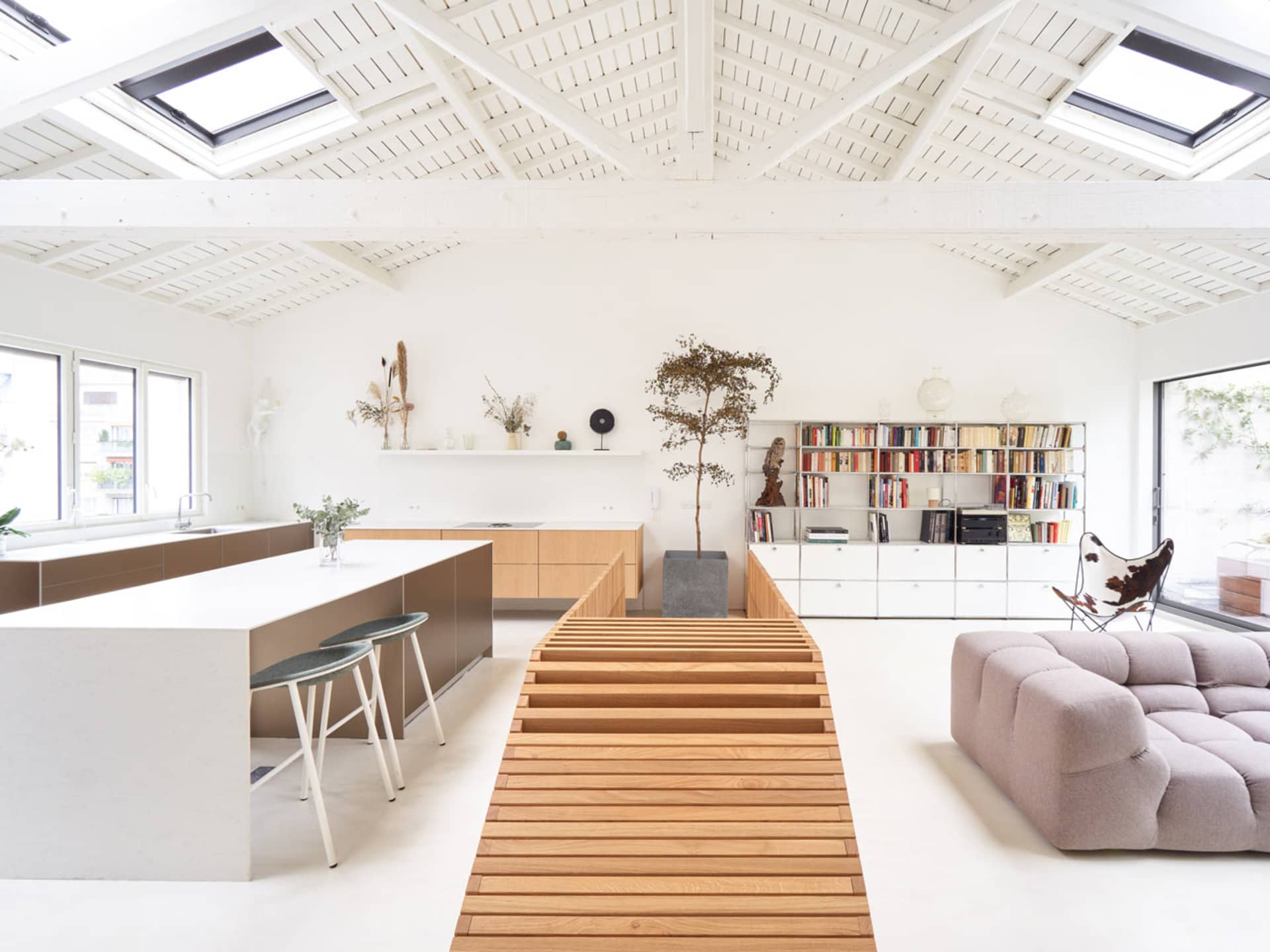 Modern living room with wood flooring, concrete walls, and minimalist design.