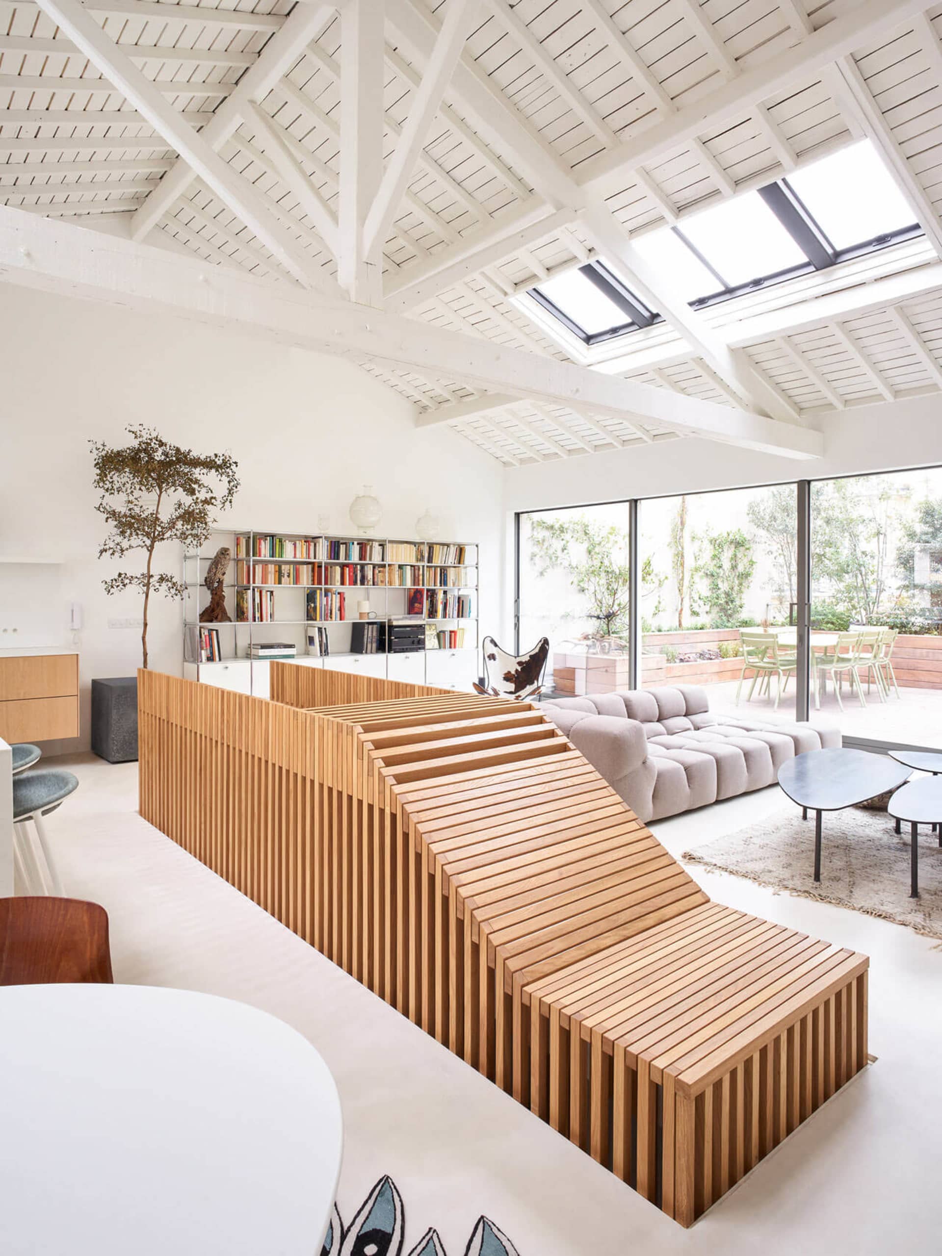 A modern living room featuring wood accents, concrete elements, and large glass windows.