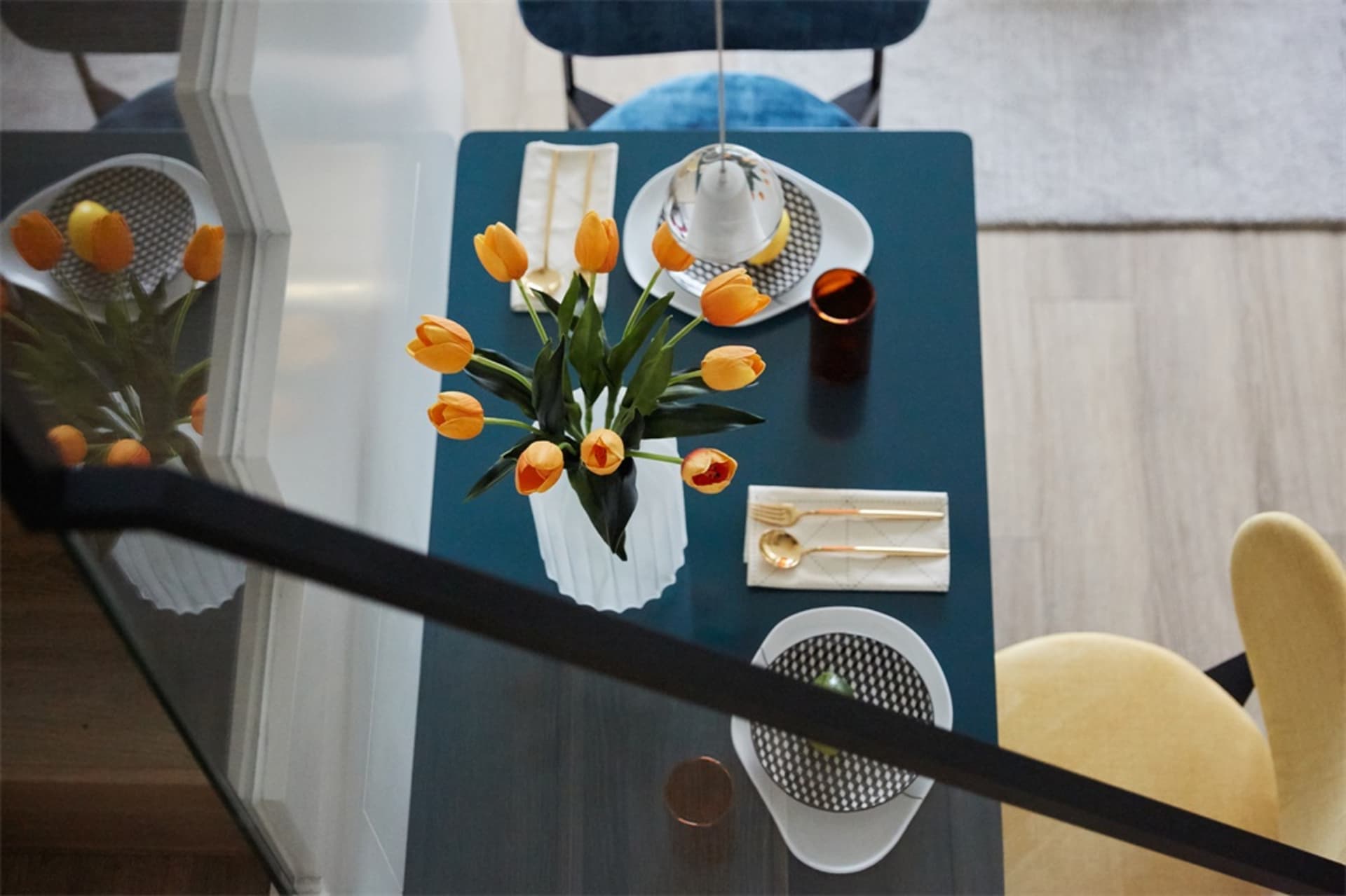 Modern table setting featuring ceramic flowers and a glass vase.