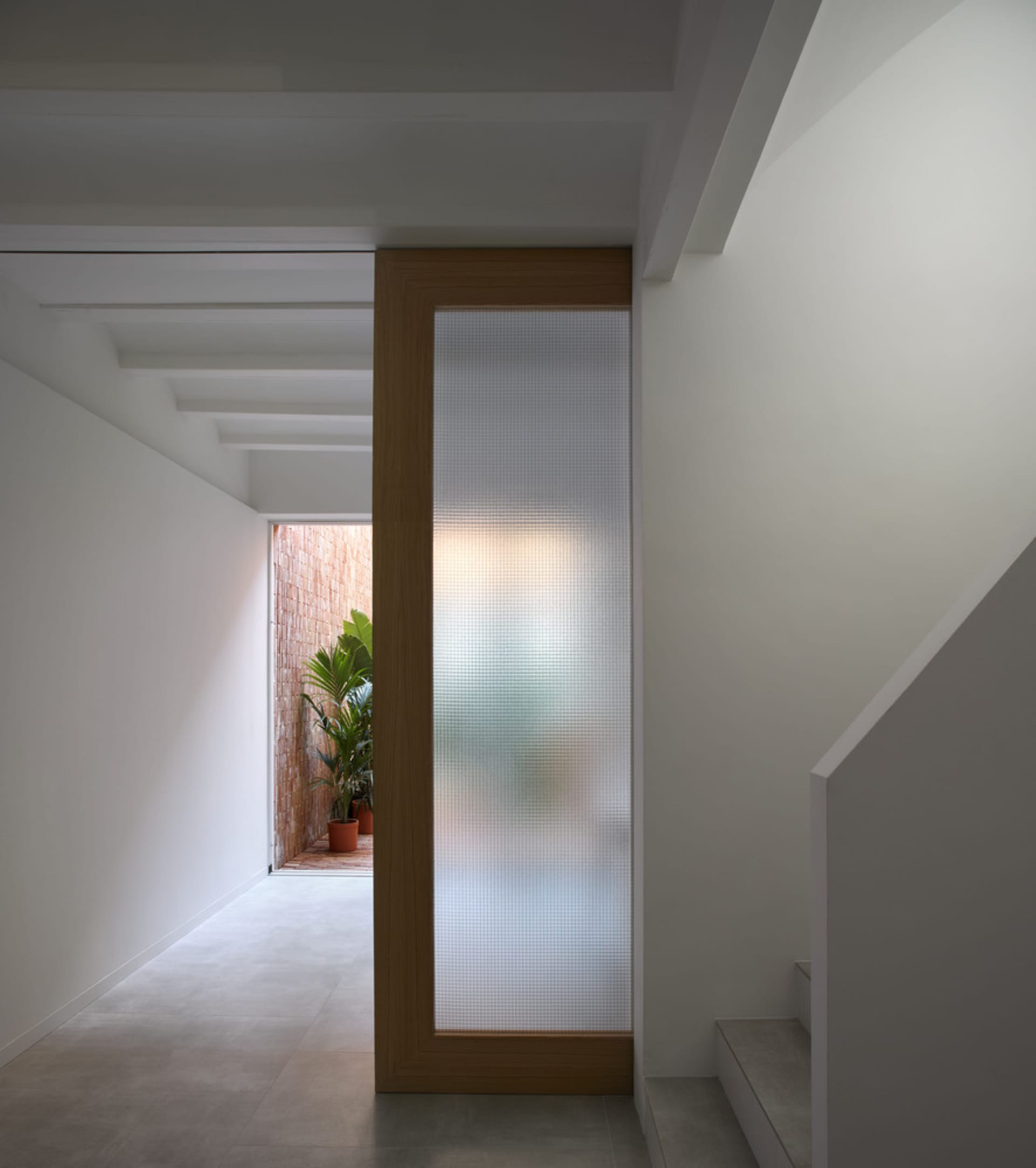 A modern entryway featuring a glass-pane door and minimalist design elements.