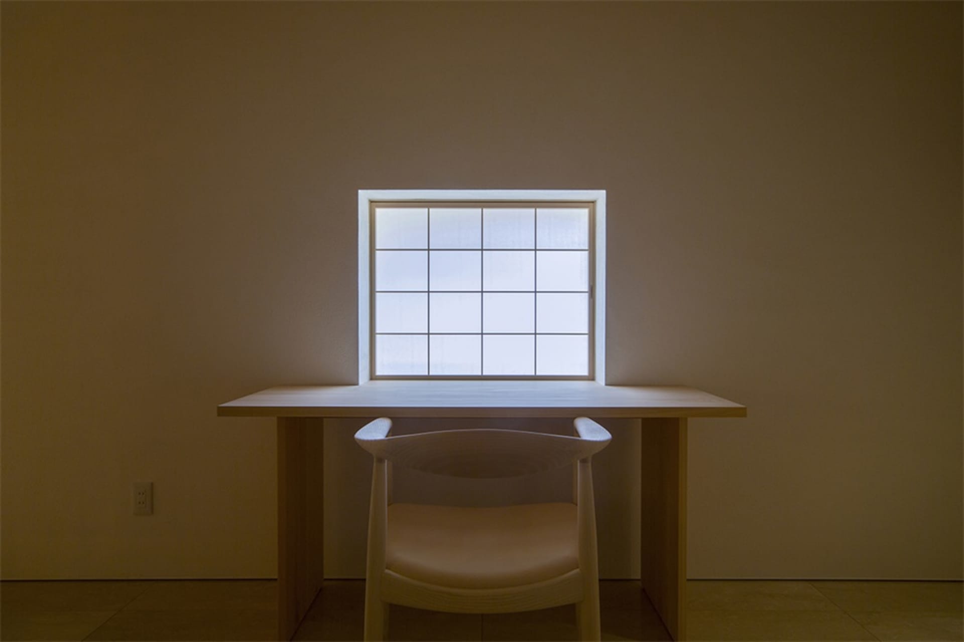 Modern workspace featuring a wooden desk and glass window.
