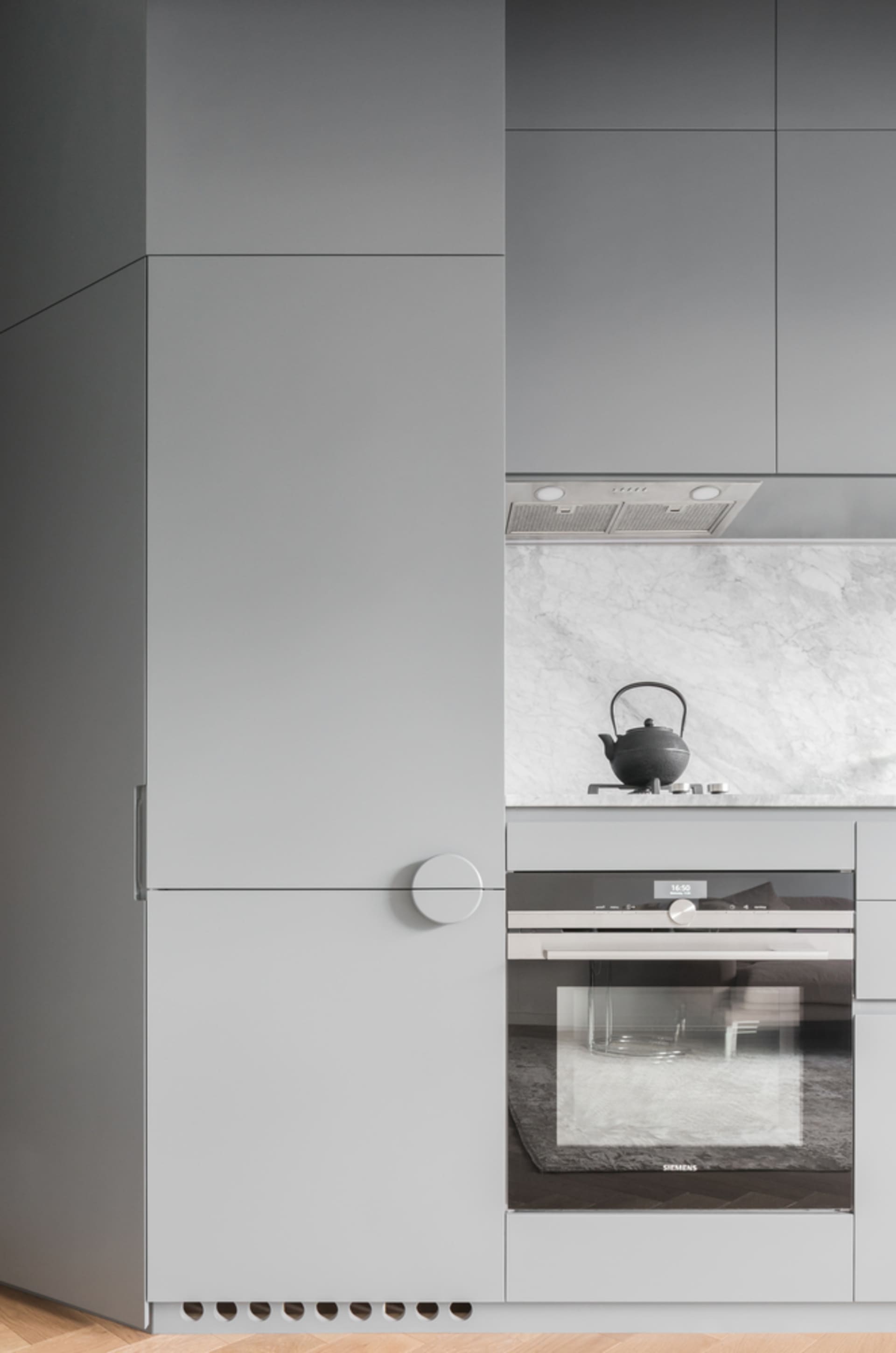 Modern kitchen featuring minimalist design with gray cabinets and appliances.