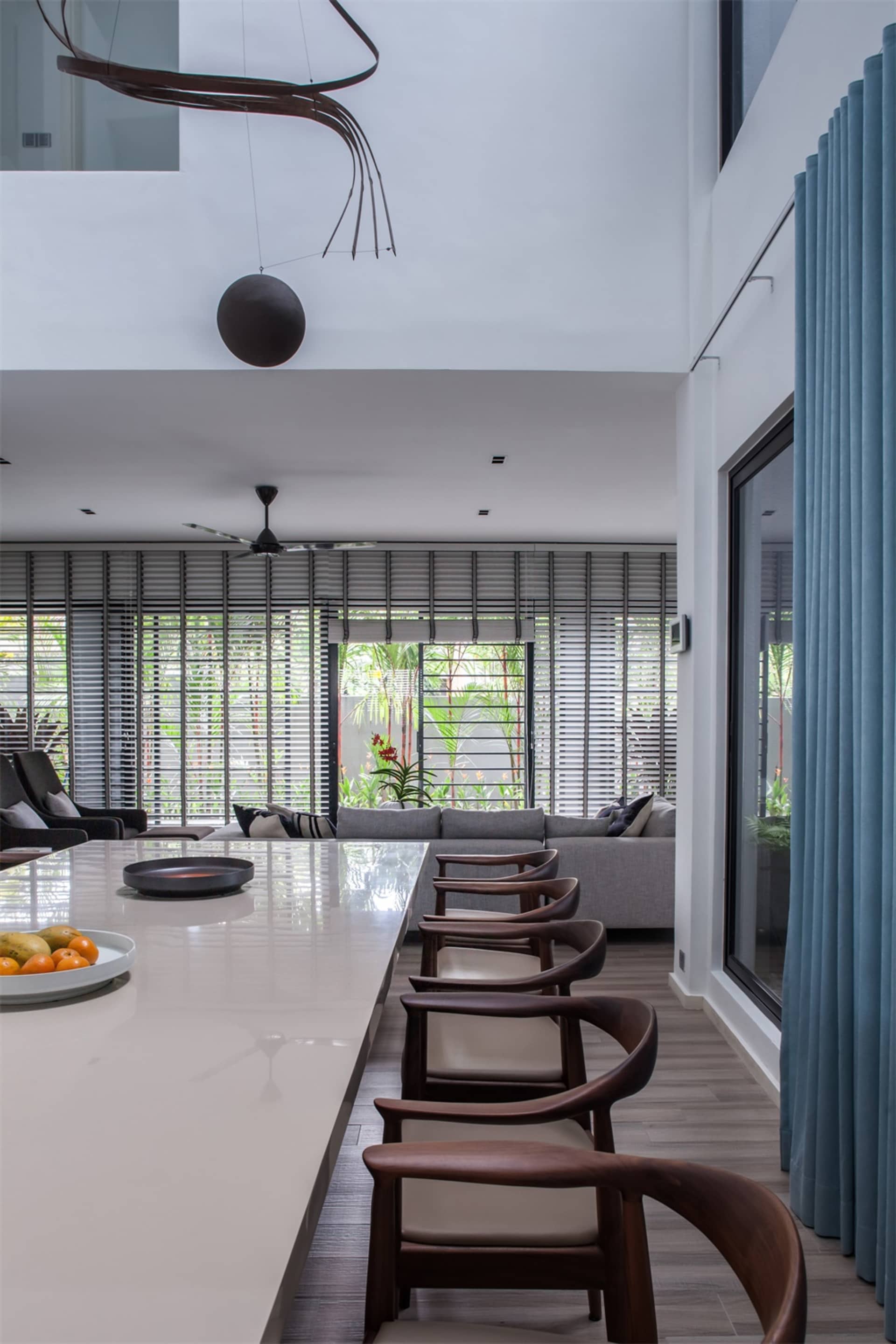 Modern interior design featuring glass, wood, and metal materials in the living and dining area.