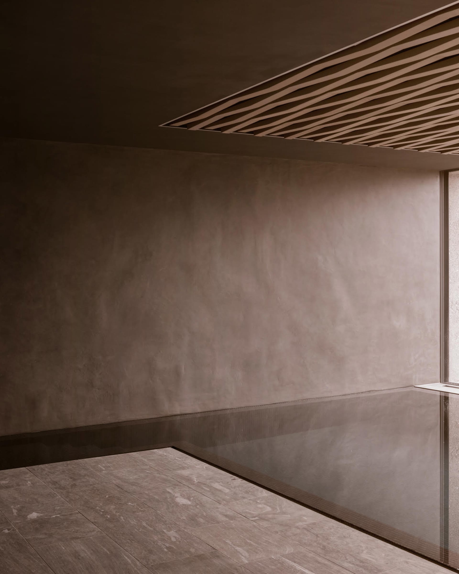 A minimalist bathroom featuring smooth, concrete surfaces.