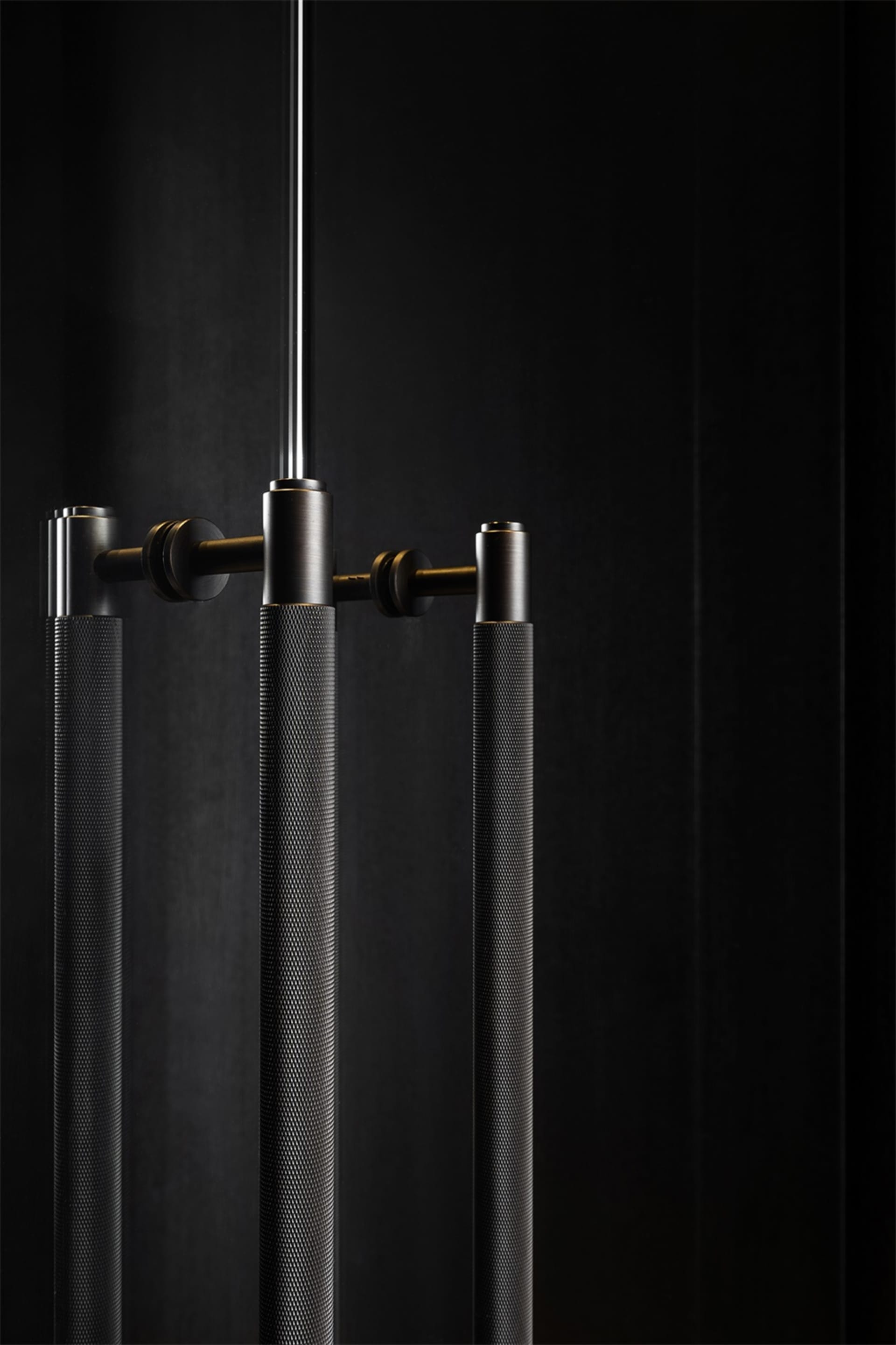 Close-up of modern lighting fixtures with a textured metal surface against a dark background.