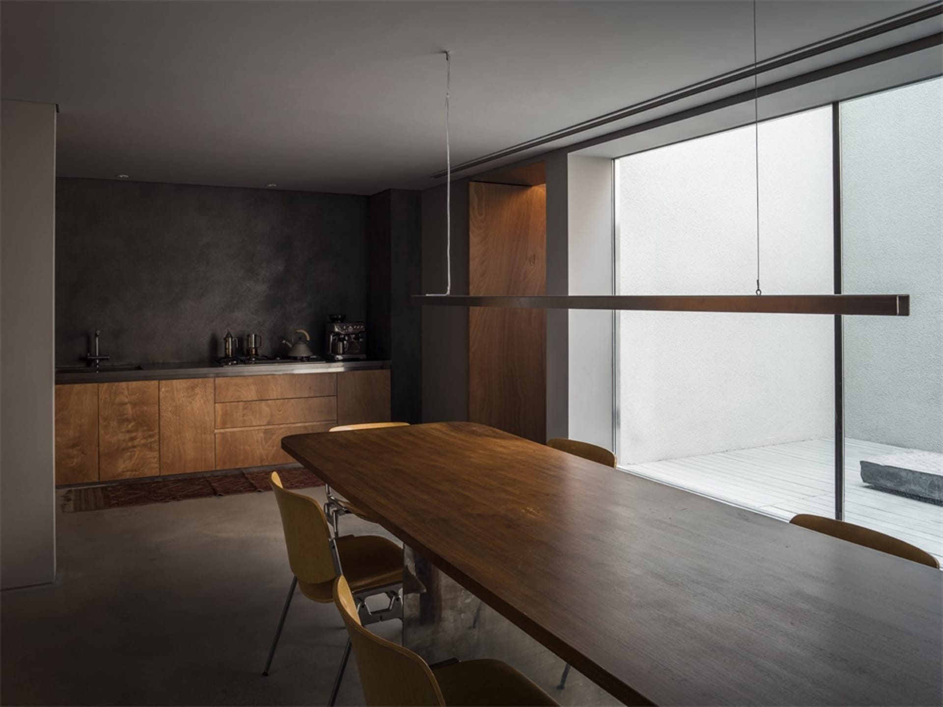 現代工業風住宅空間，設有金屬廚房及木質餐桌椅組。