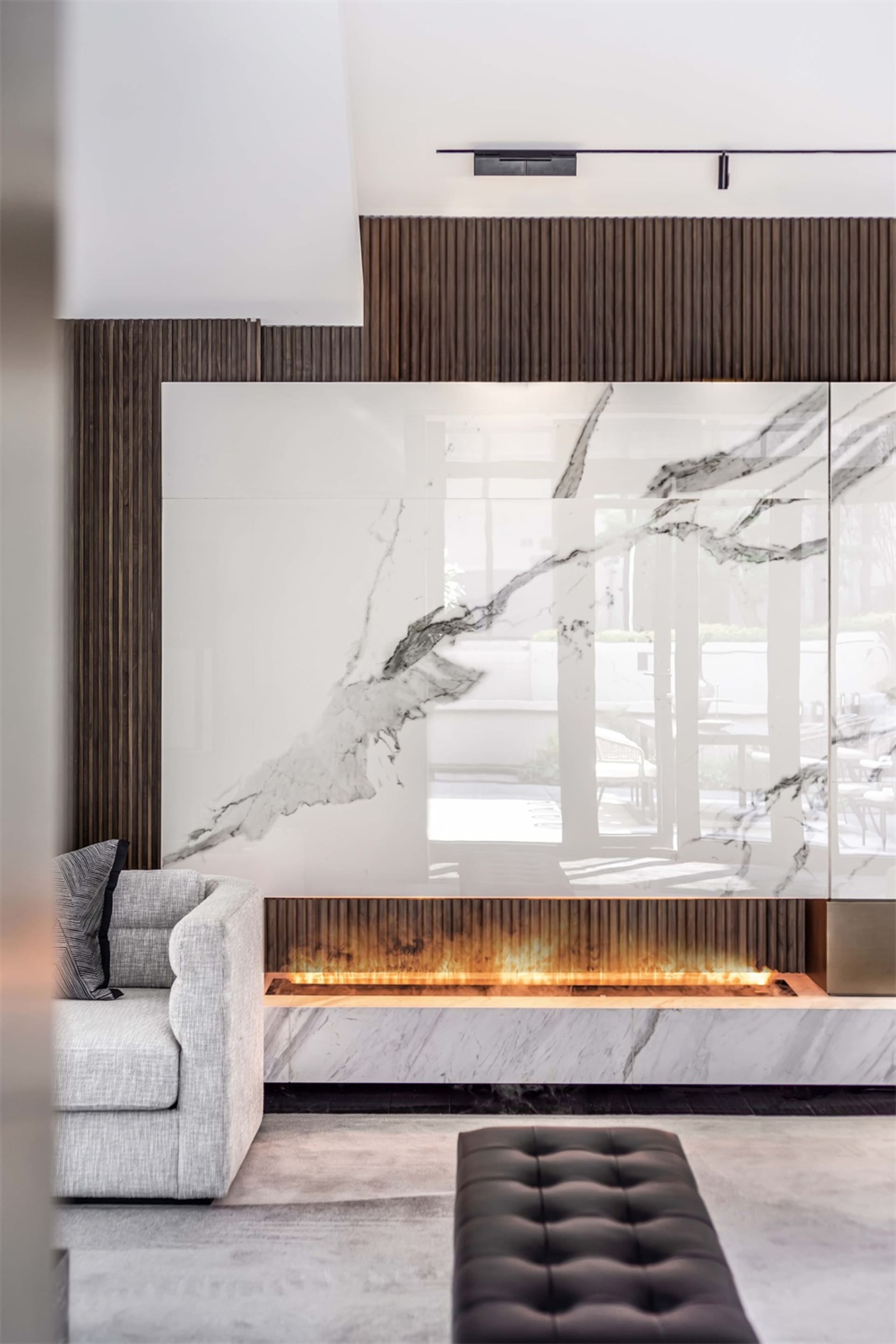 A modern living room with marble fireplace and wooden accents.