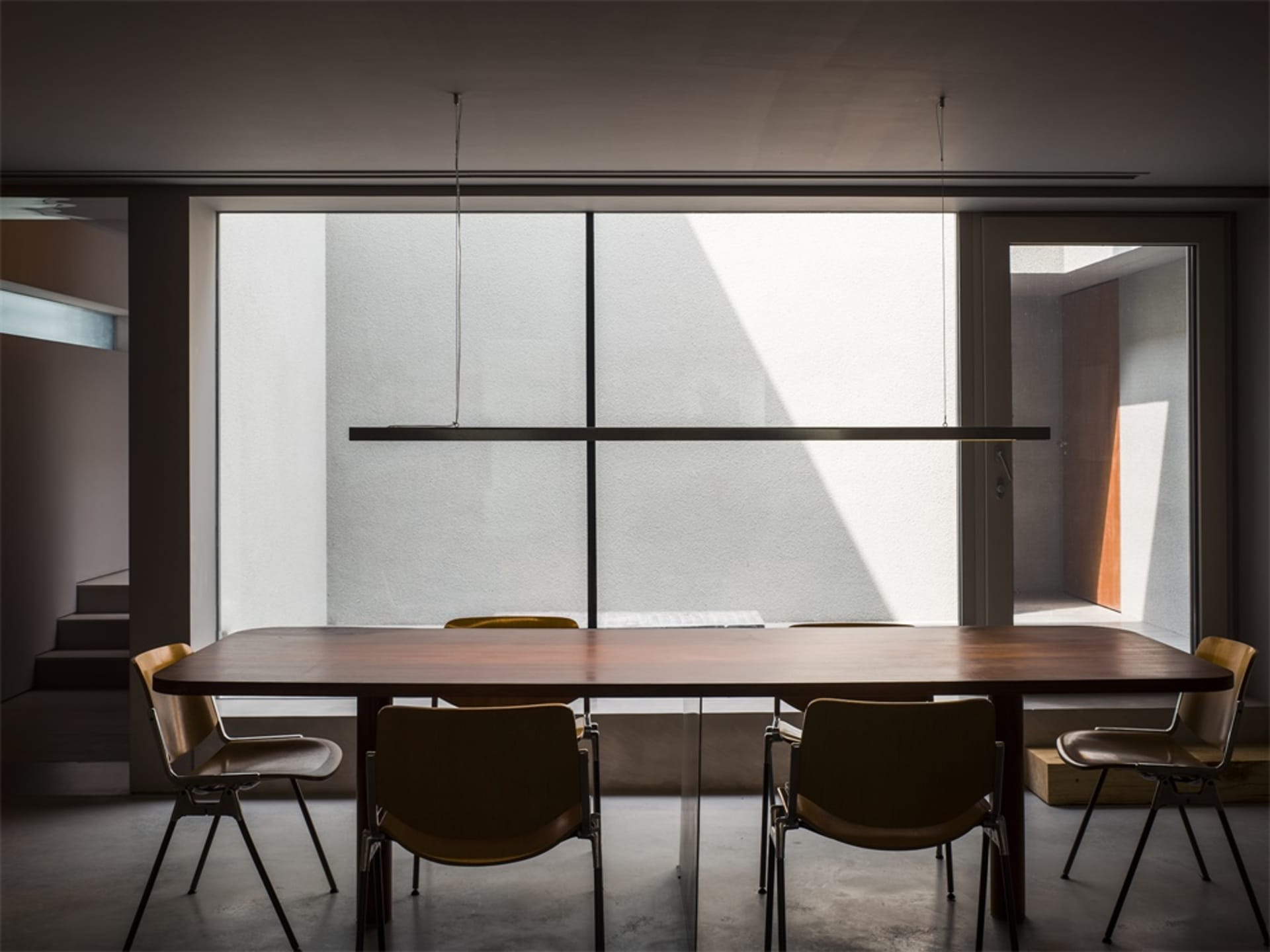 An interior office space featuring a modern design with minimalist furniture and wooden elements.