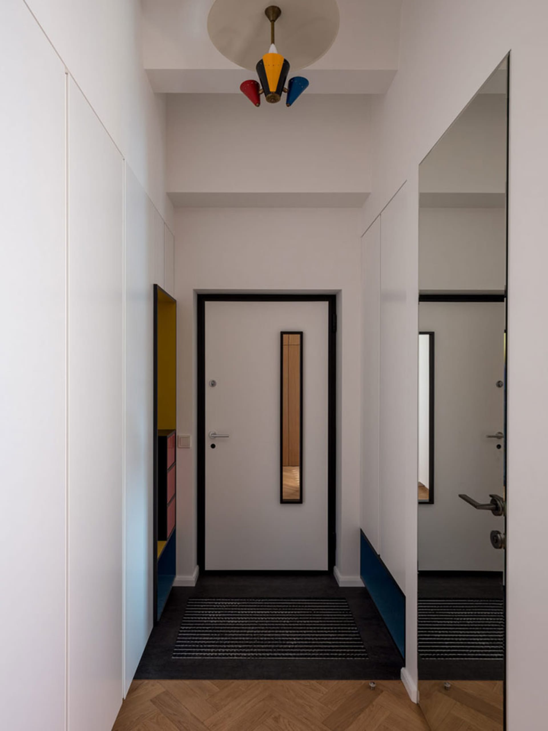 A minimalist interior with white walls, wooden flooring, and metallic accents.