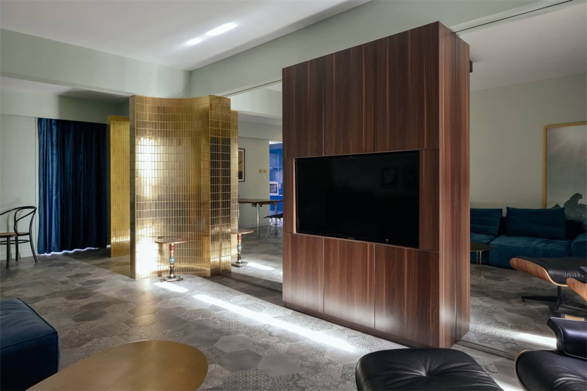 A modern residential living room featuring gold metallic partitions and wooden cabinets.