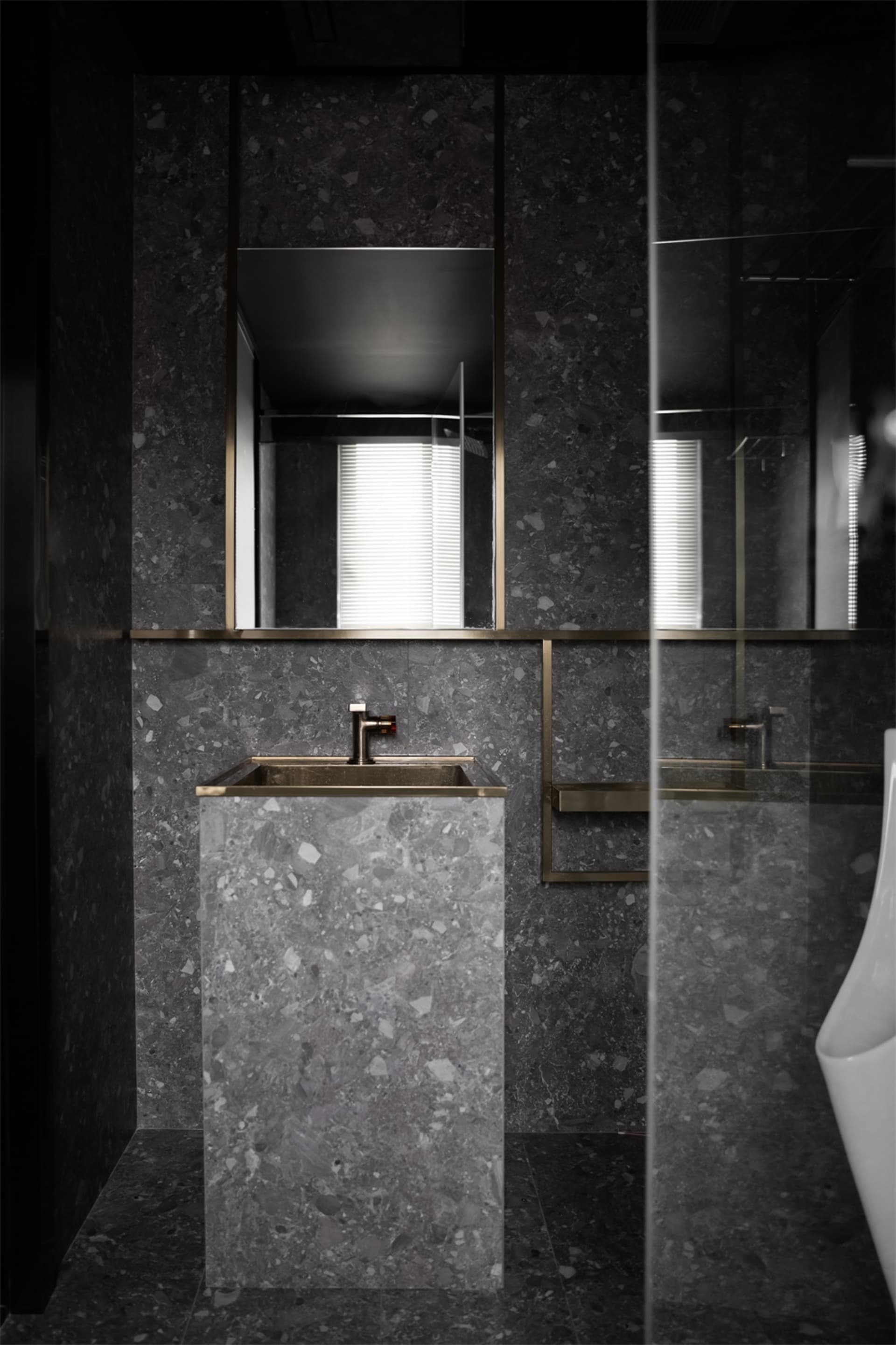 A modern bathroom featuring a terrazzo sink and countertop.