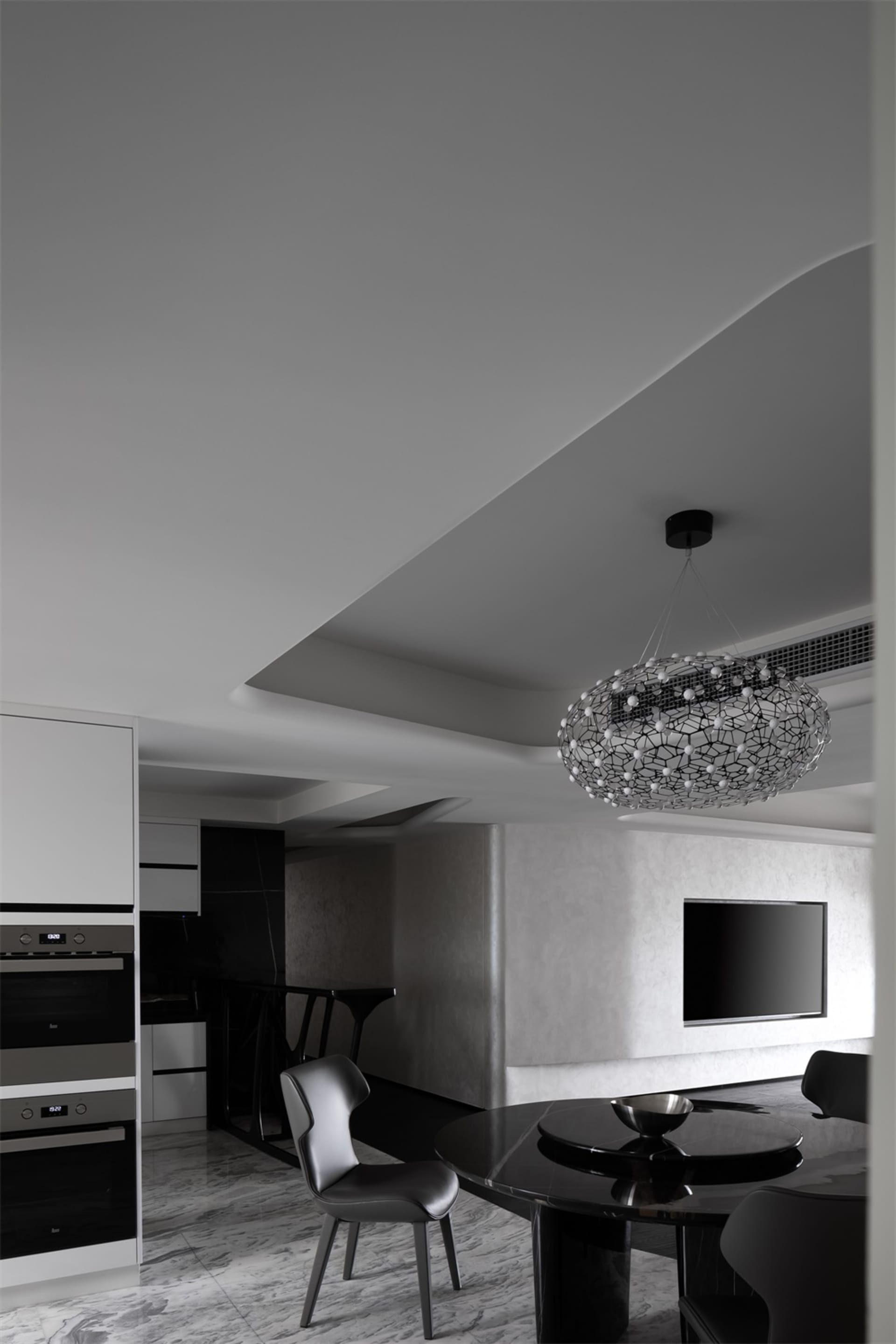 Modern dining room featuring a black and white metallic table and chairs.
