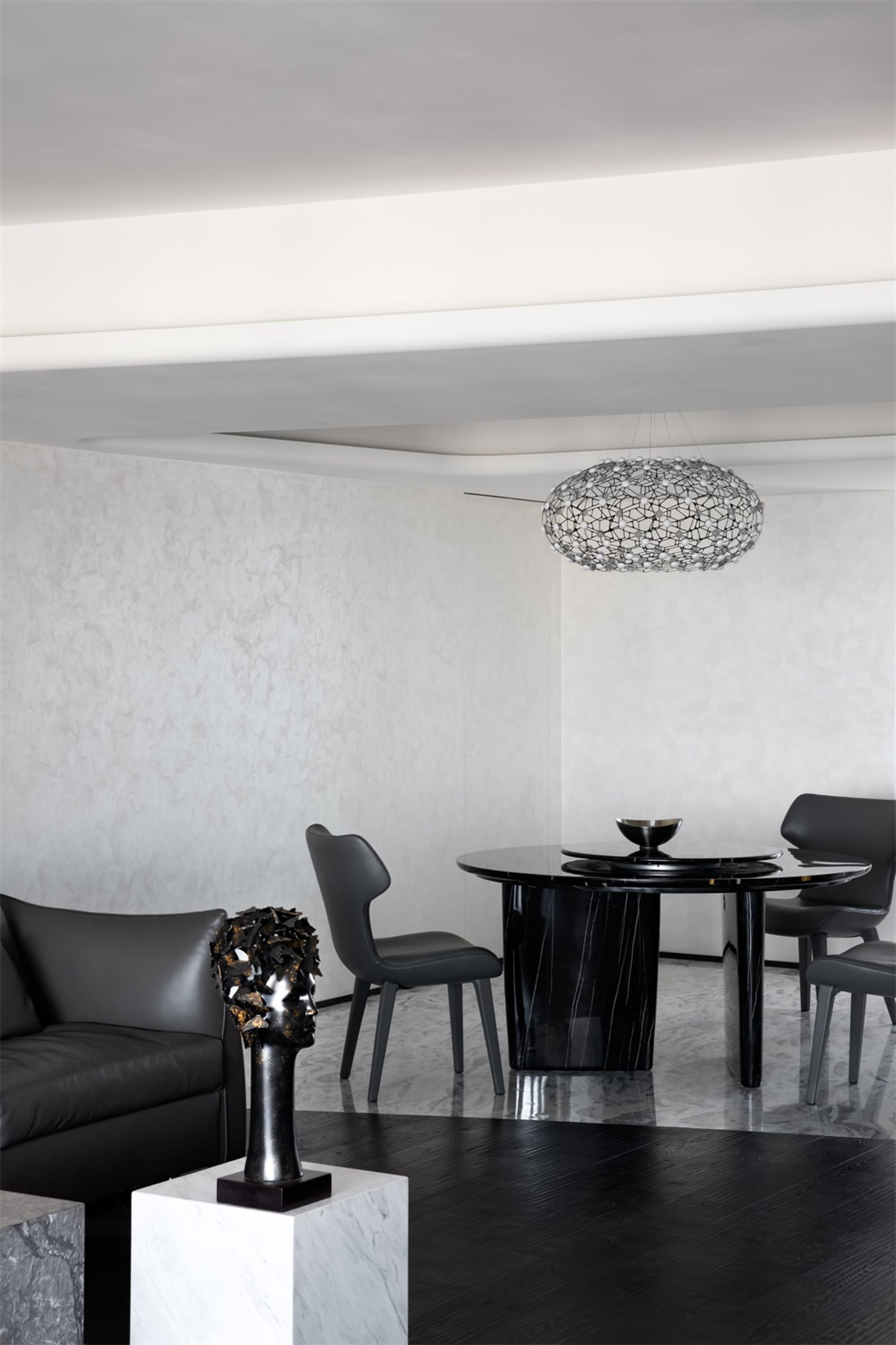 Modern dining room featuring a black marble dining table, metal chairs, and a geometric glass chandelier.