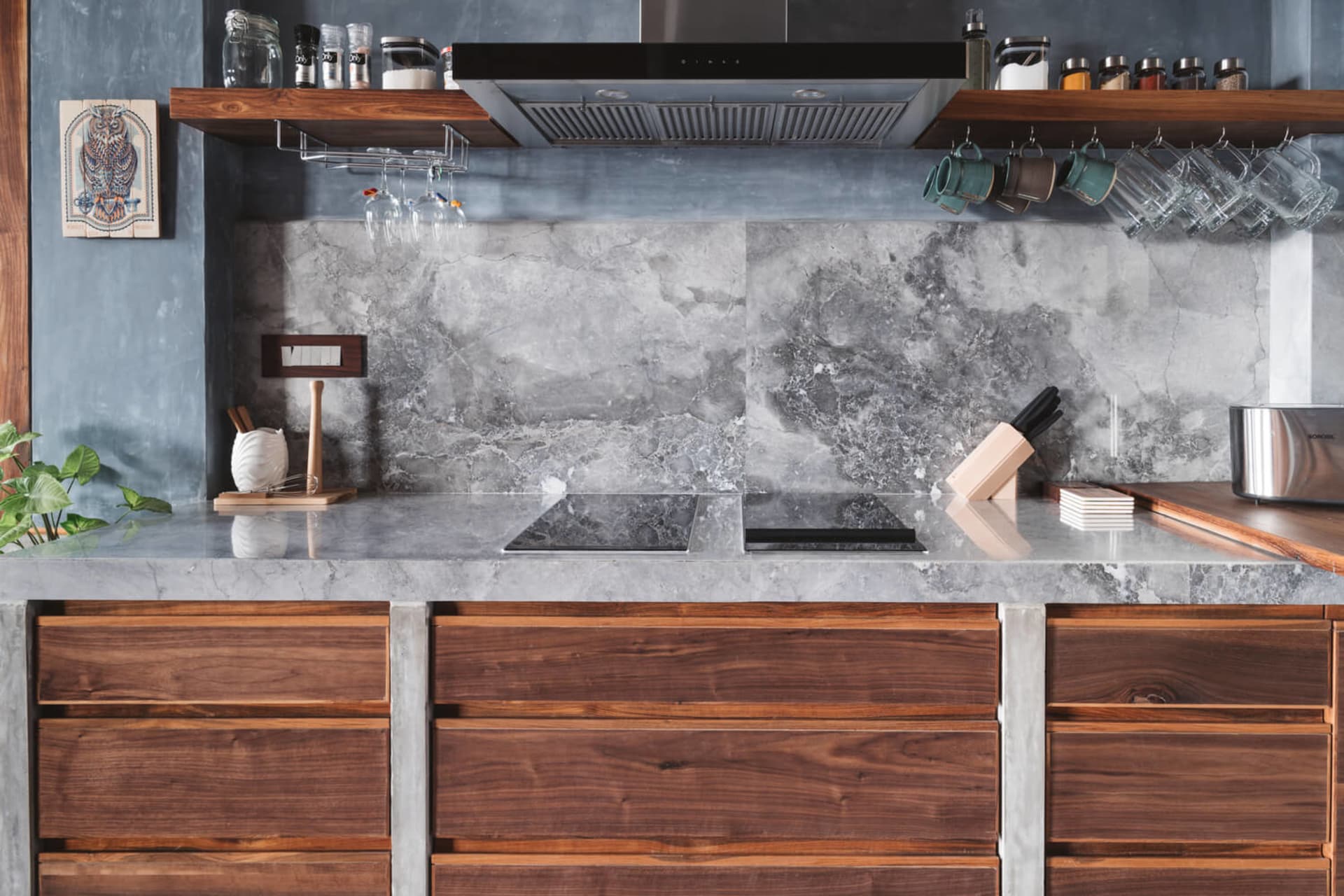 Modern minimalist kitchen featuring granite countertops and a marble backsplash.