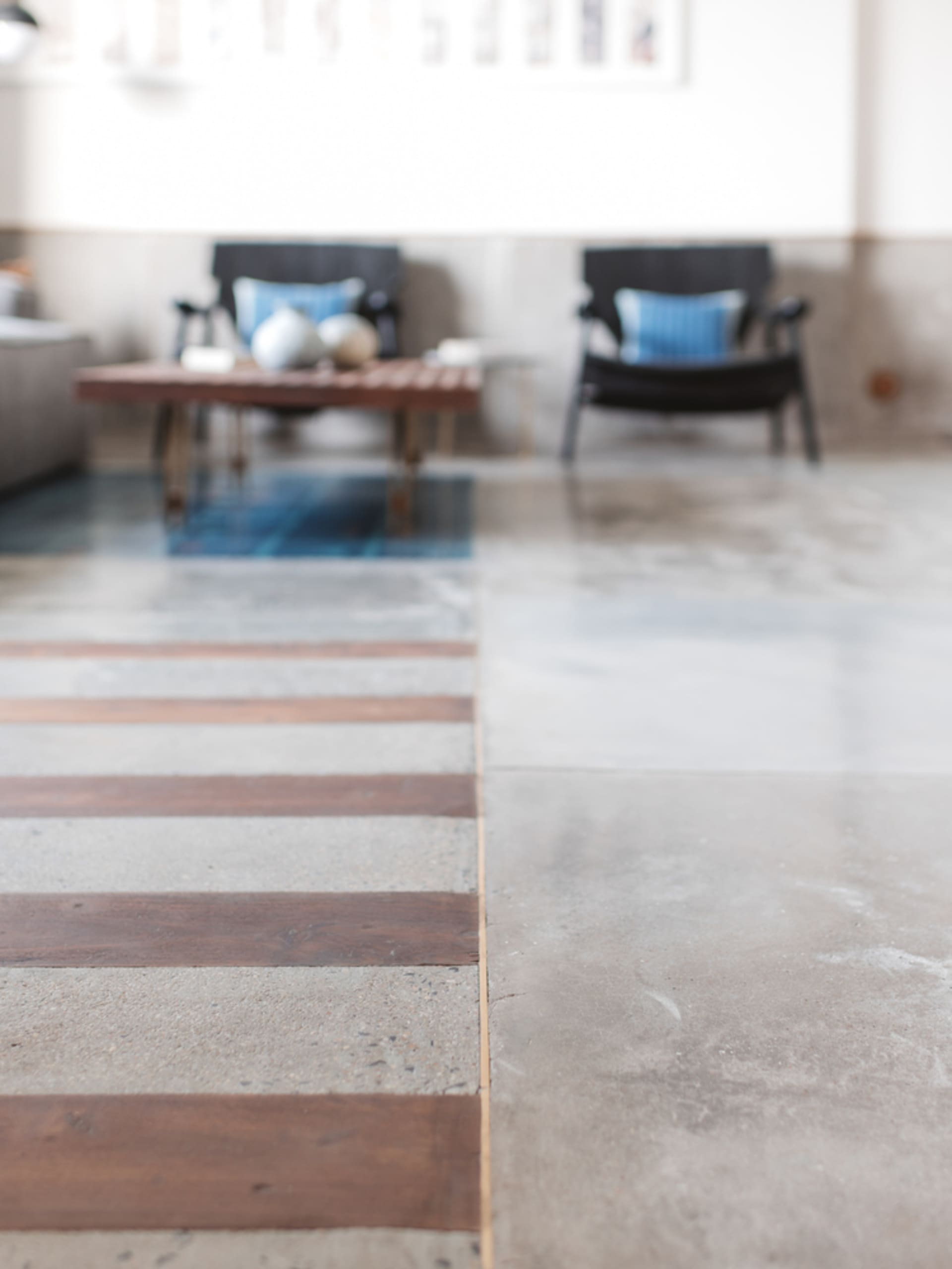 A spacious lounge area with concrete flooring and wooden accents.