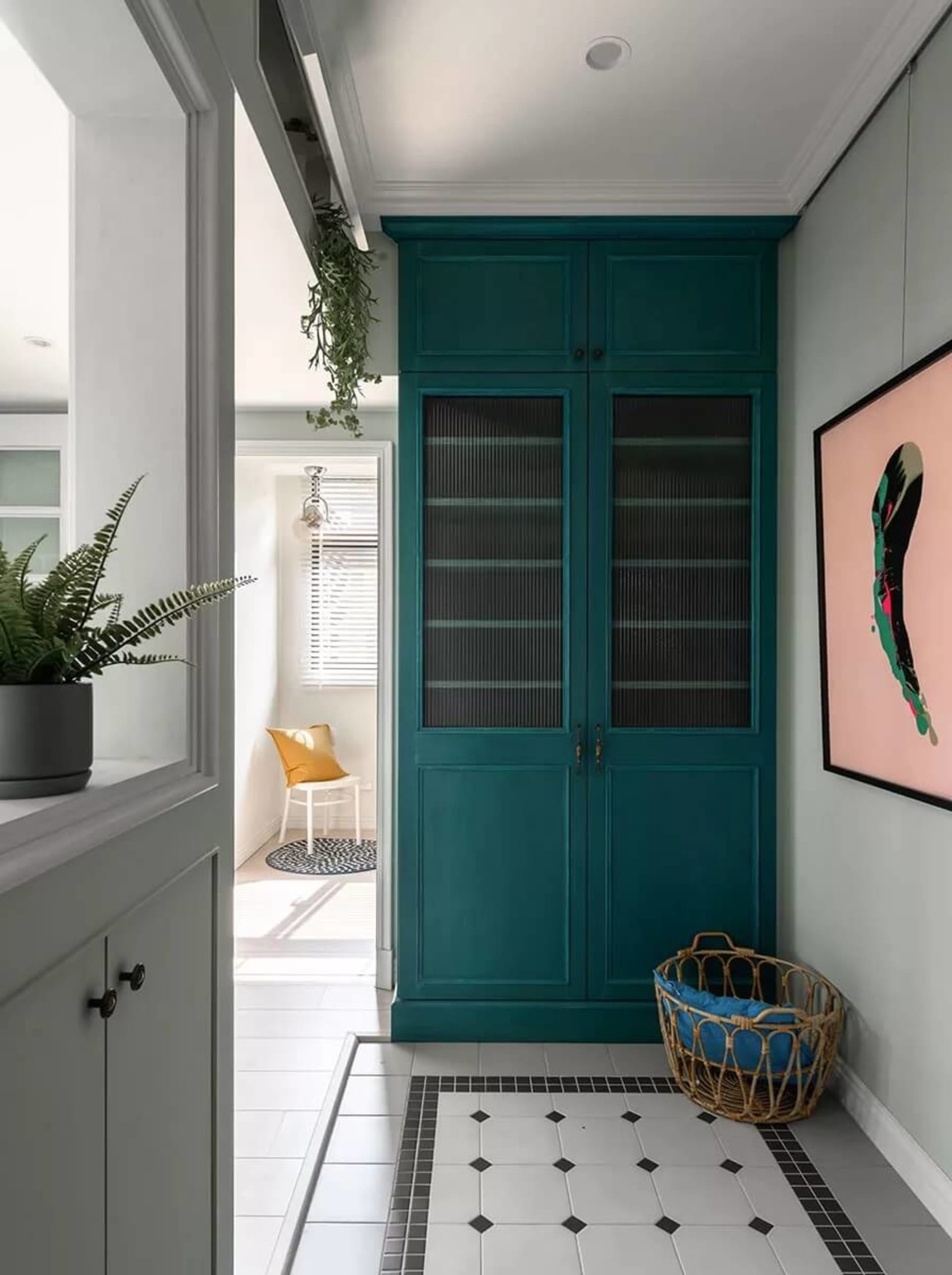 Teal wooden cabinet in an entrance hallway.