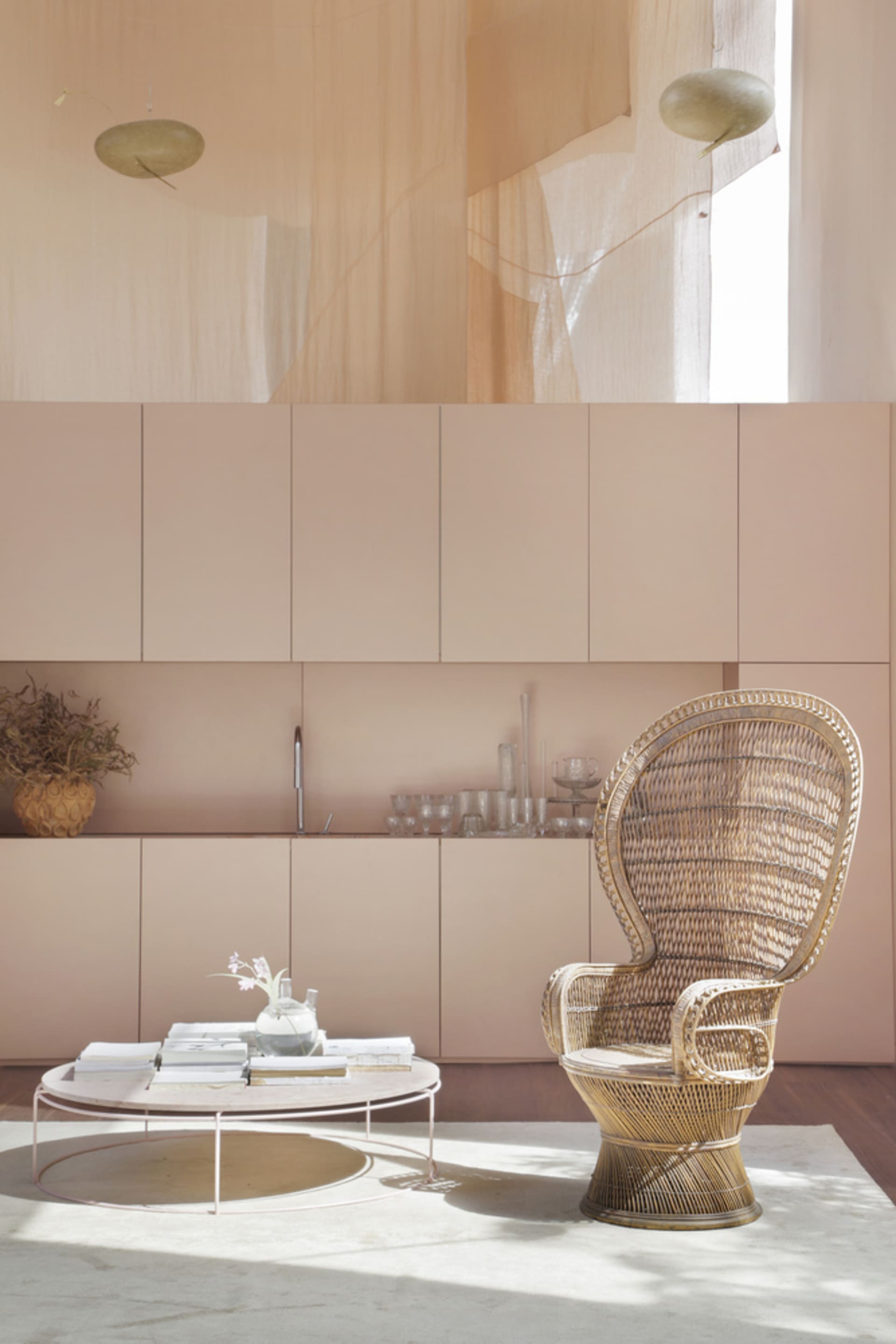 A cozy and stylish interior space with a modern wicker chair, coffee table, and cabinets.